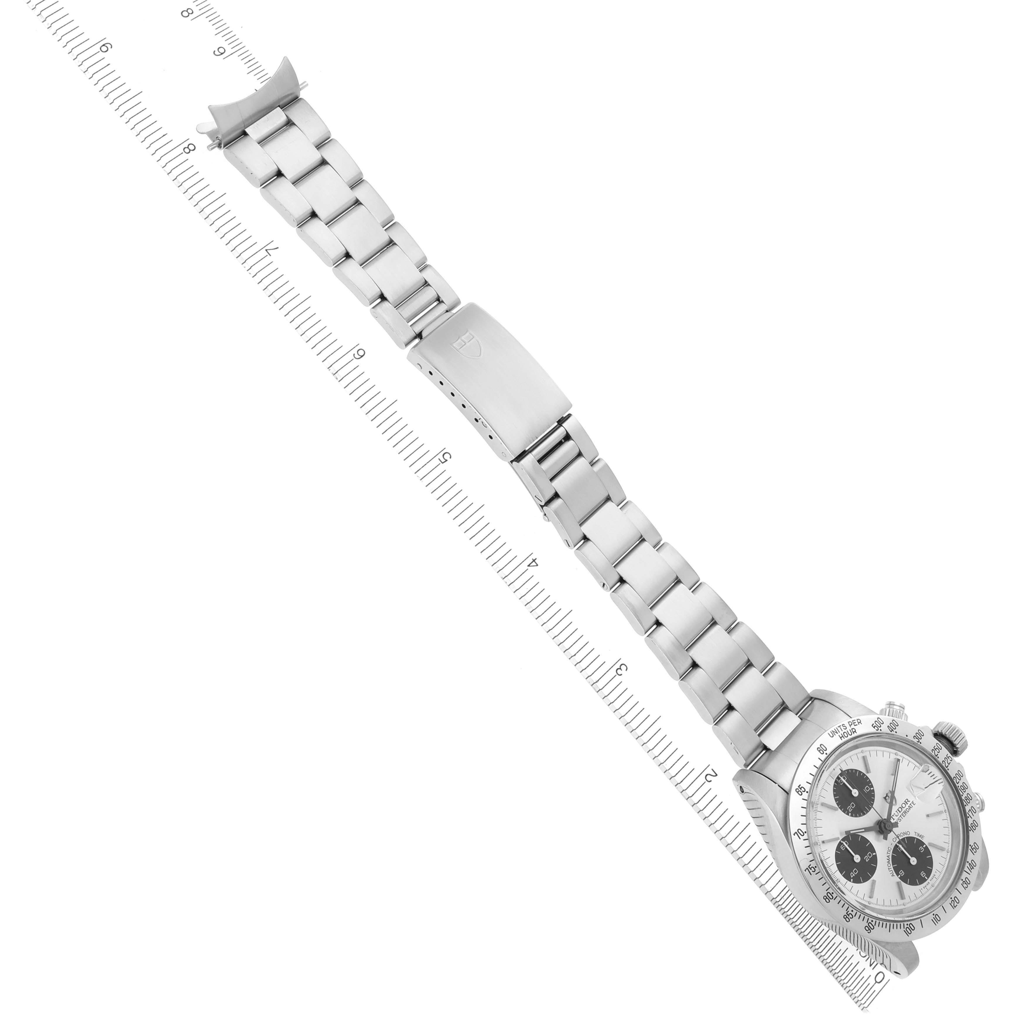 The Tudor Prince 79180 Men's Stainless Steel Silver Dial watch is shown from a top-down angle, displaying its face, bezel, and full metal bracelet alongside a ruler for scale.