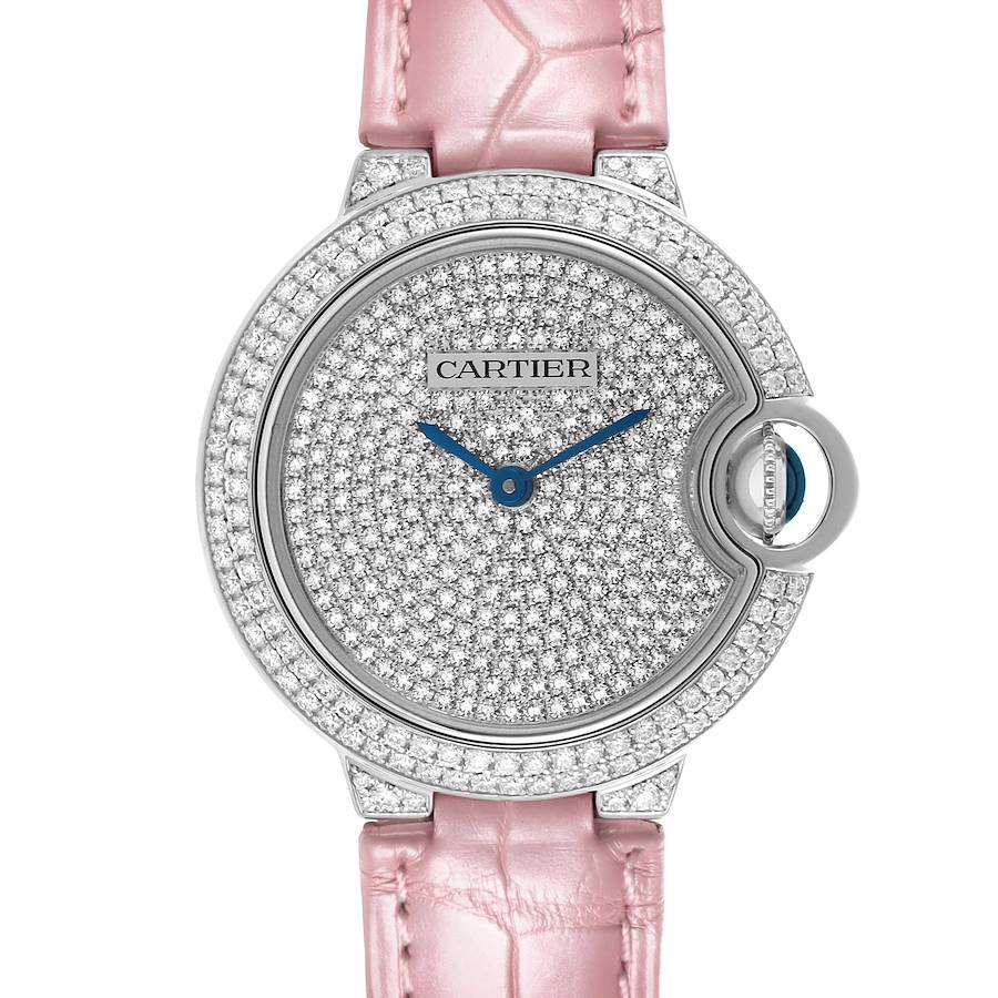 The Cartier Ballon Bleu watch is shown from the front, displaying its diamond-studded face and pink leather strap.