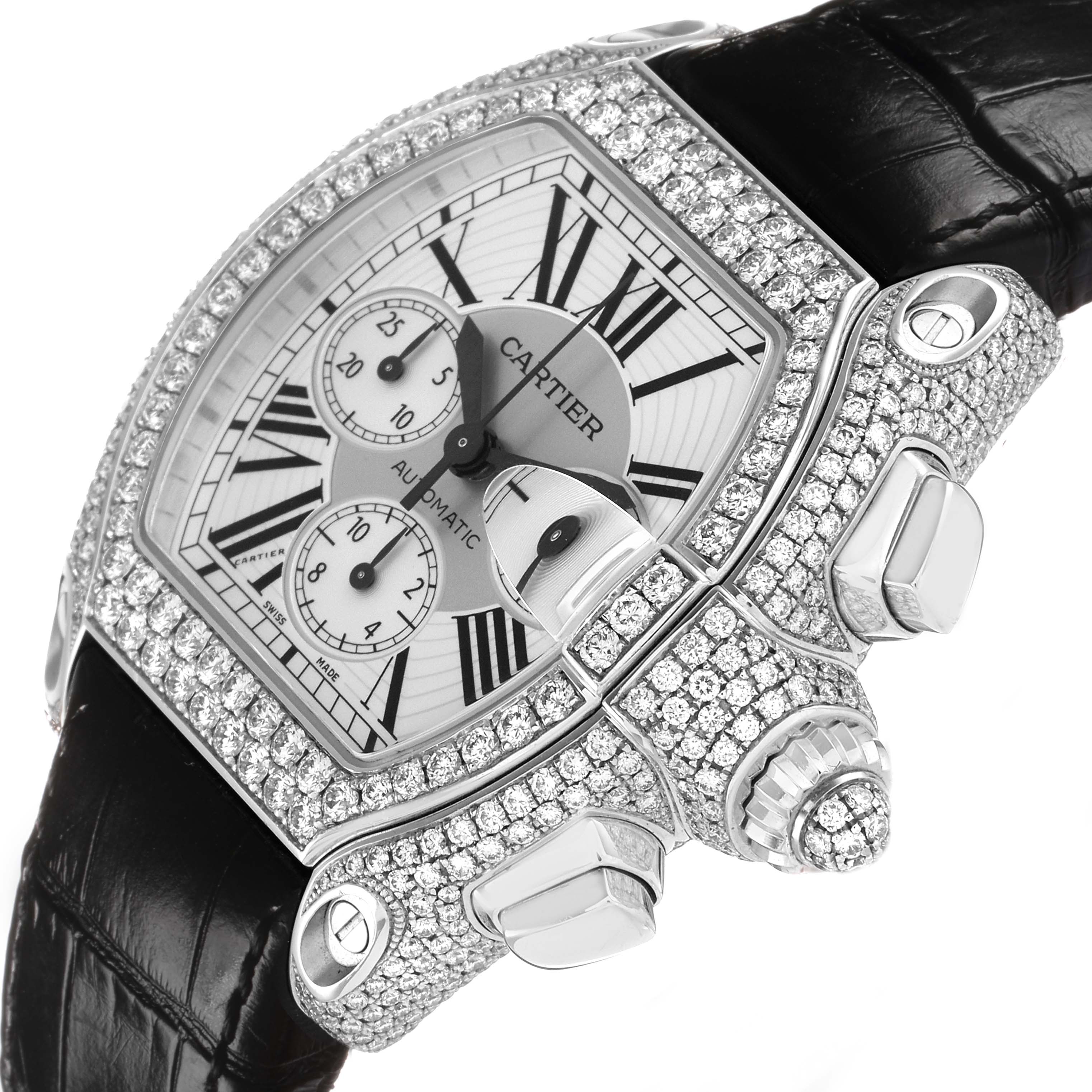 The Cartier Roadster WE50032H Men
s White Gold Silver Dial watch is shown at a tilted angle, highlighting the diamond-encrusted case, crown, and black strap.