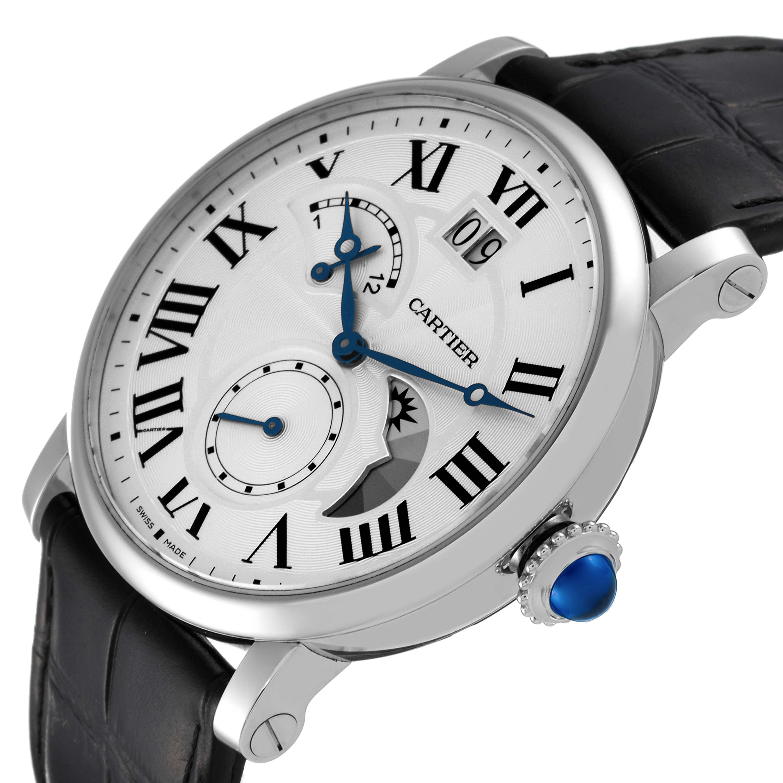 The image shows a close-up angle of the Rotonde watch by Cartier, highlighting the face, Roman numerals, and blue cabochon crown.