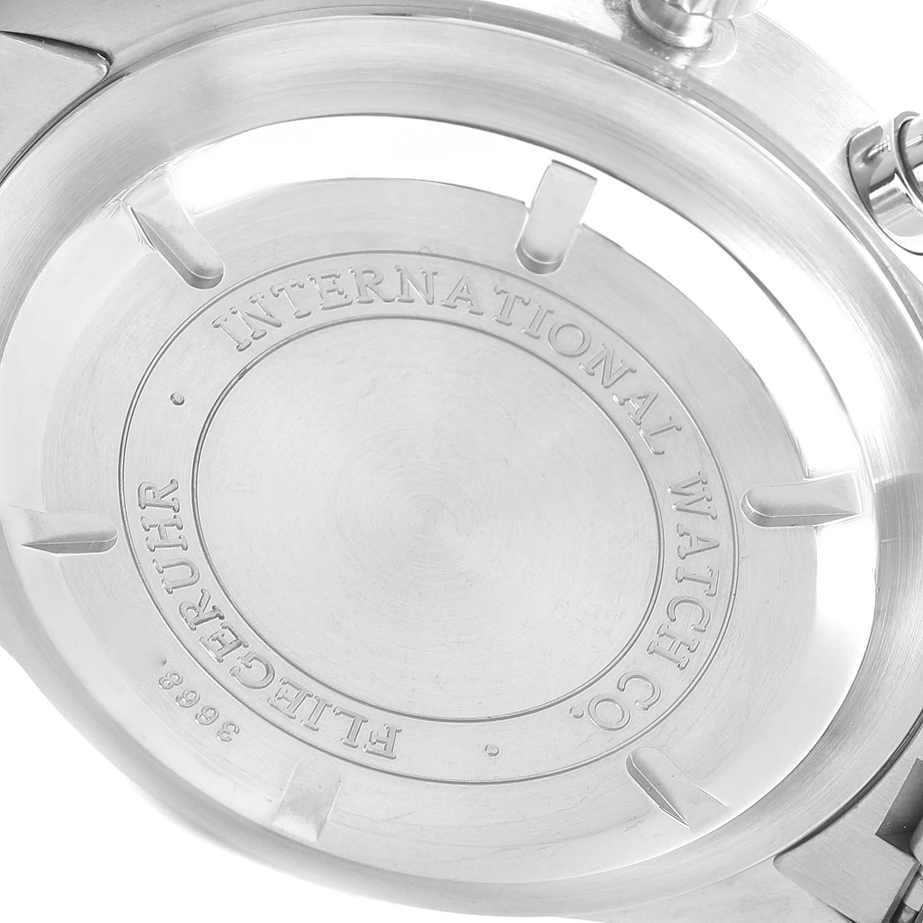 The photo shows the back of the Pilot model watch by IWC with engravings and screws visible.