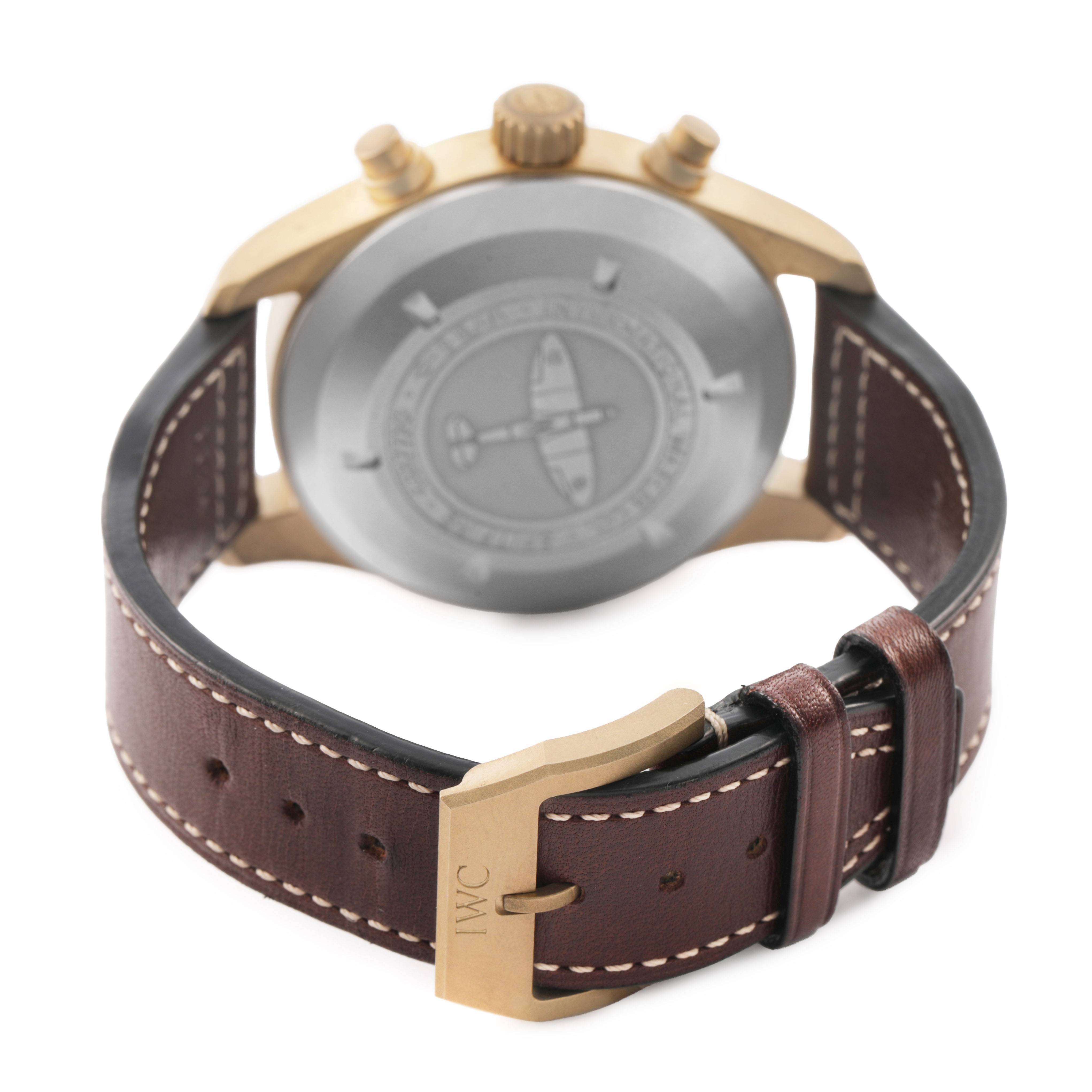 The IWC Pilot IW387902 Men's Bronze Green Dial watch is shown from the back, highlighting the case back, crown, pushers, and leather strap with the IWC buckle.