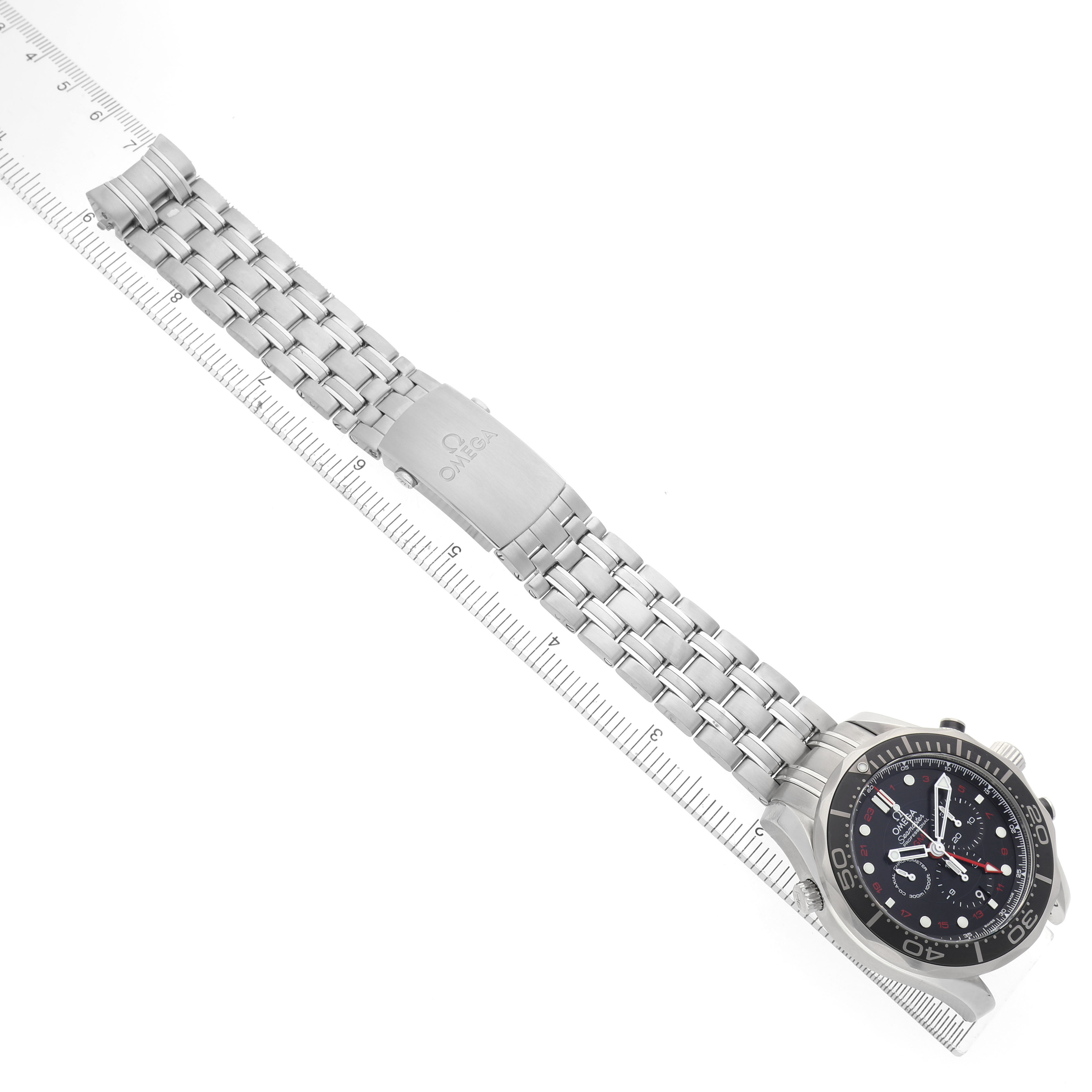 The Omega Seamaster 212.30.44.52.01.001 Men's Stainless Steel Black Dial watch is shown from a top angle, highlighting the face, bracelet, and clasp alongside a ruler for scale.