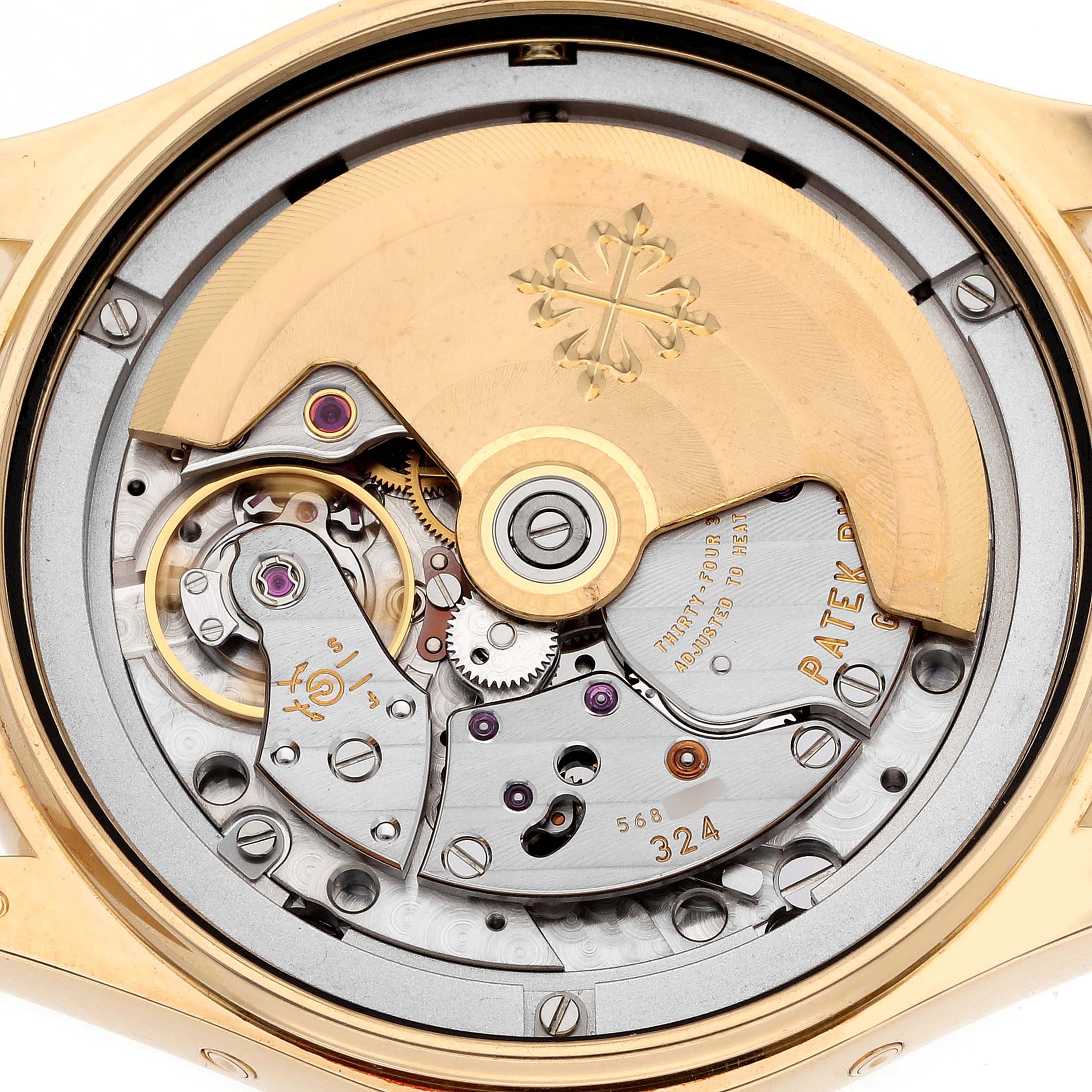 The image shows the intricate movement of the Patek Philippe Complications 4936J - 001 Men's Yellow Gold Mother of Pearl Dial model viewed from the back, highlighting the rotor and gears.