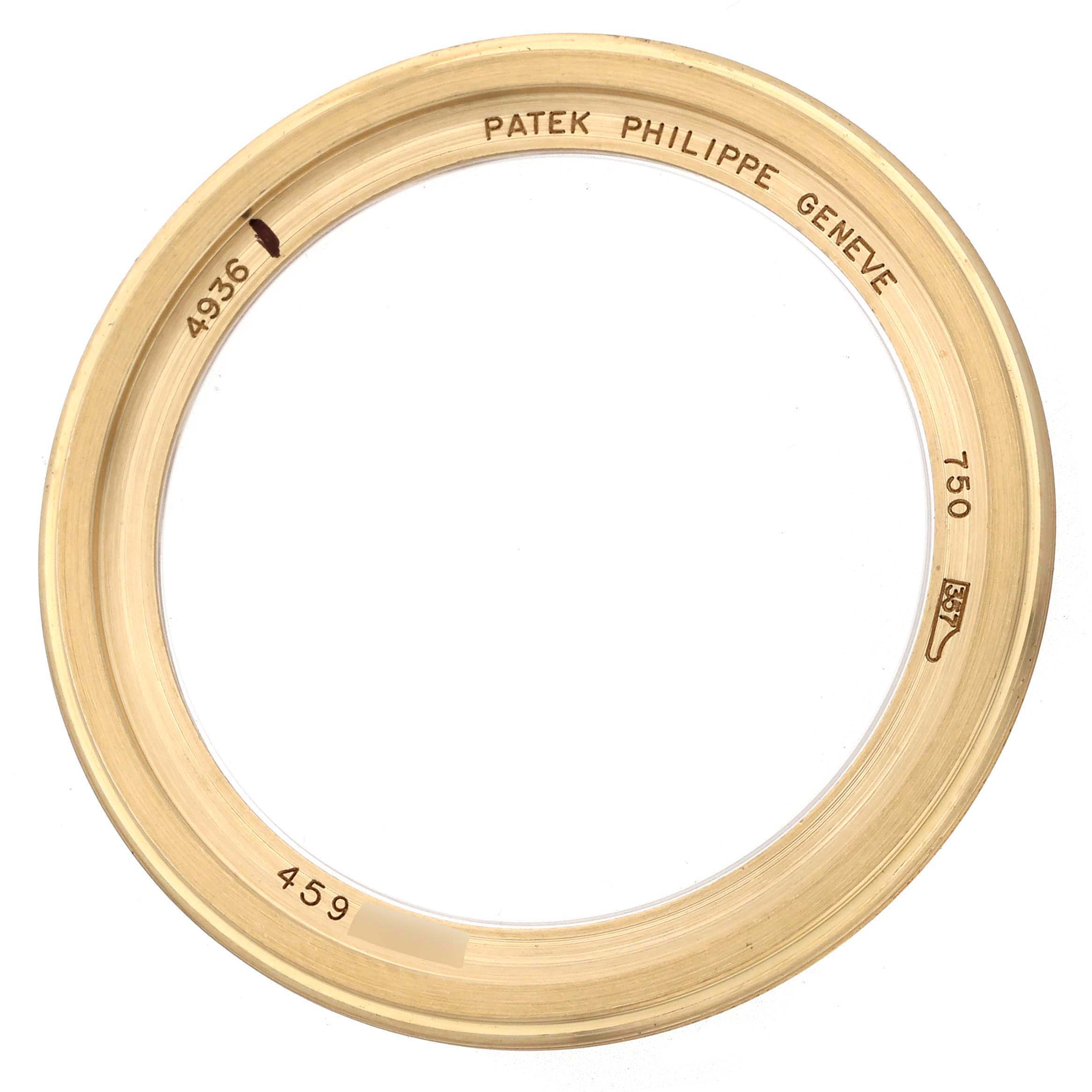 This image shows a gold bezel from the Patek Philippe Complications 4936J - 001 Men's Yellow Gold Mother of Pearl Dial model, viewed from above with engravings visible.