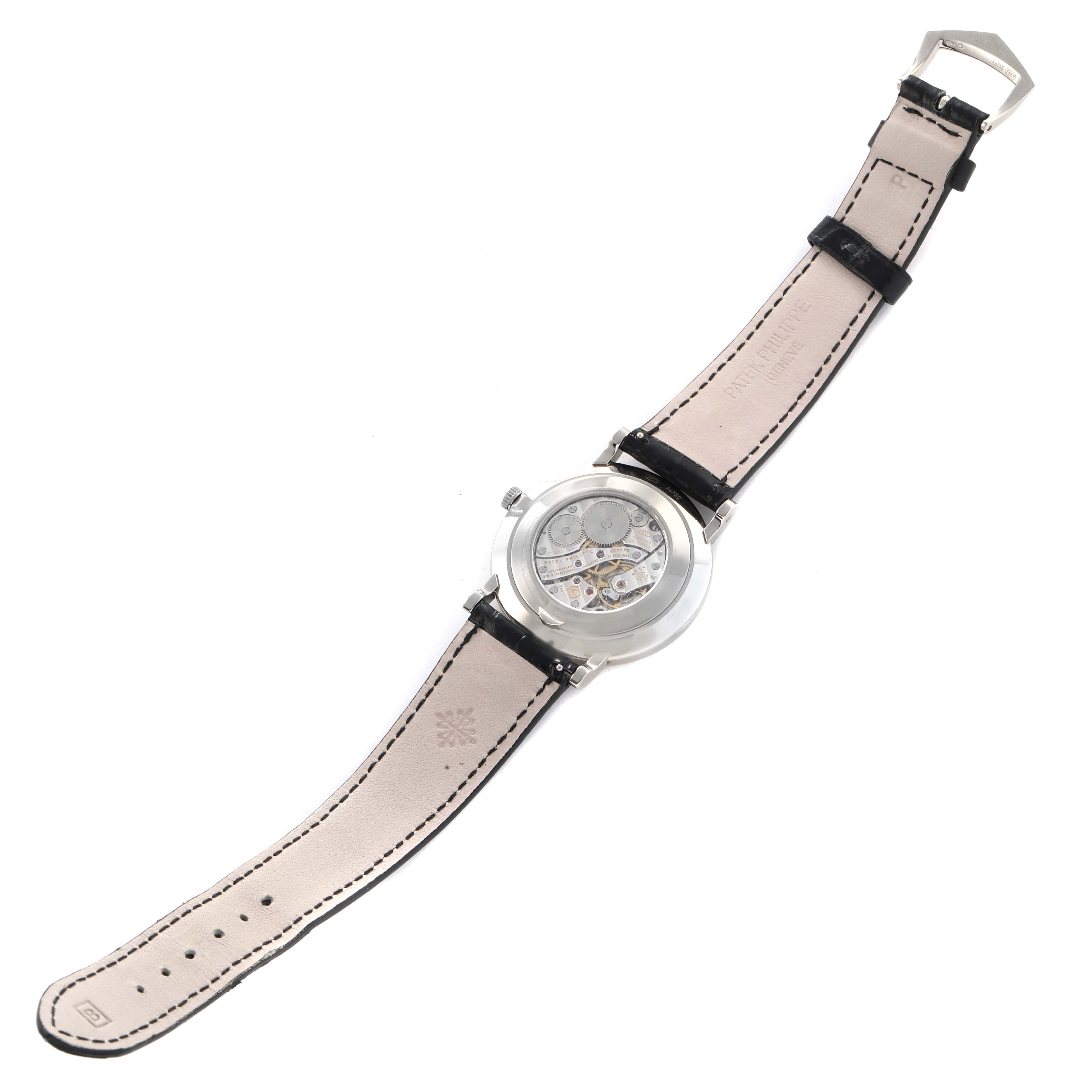 The image shows the back of a Patek Philippe Calatrava 5119G Men
s White Gold White Dial, revealing its movement, strap, and buckle.