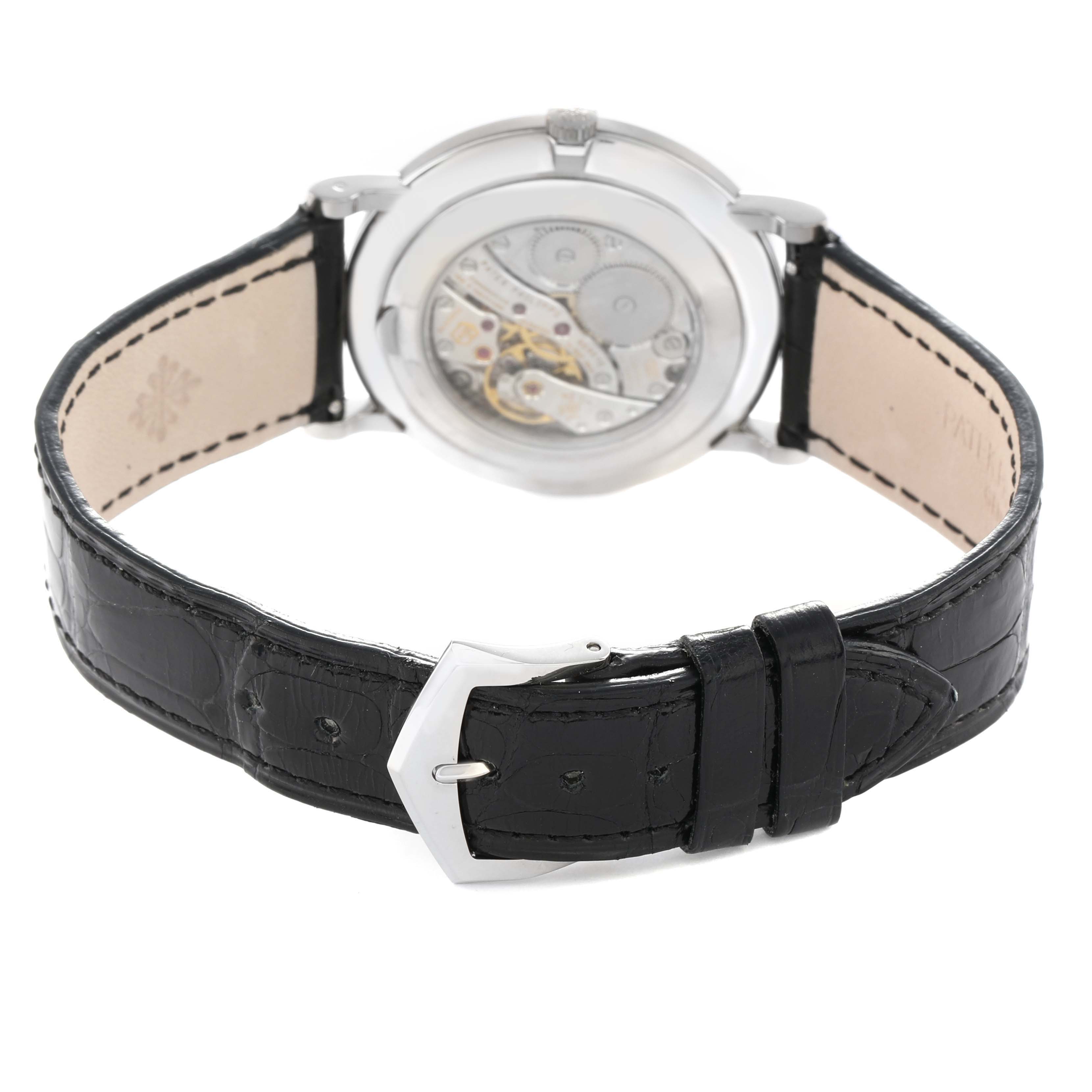 The image shows the back view of a Patek Philippe Calatrava 5119G Men
s White Gold White Dial, highlighting the movement and black leather strap with buckle.