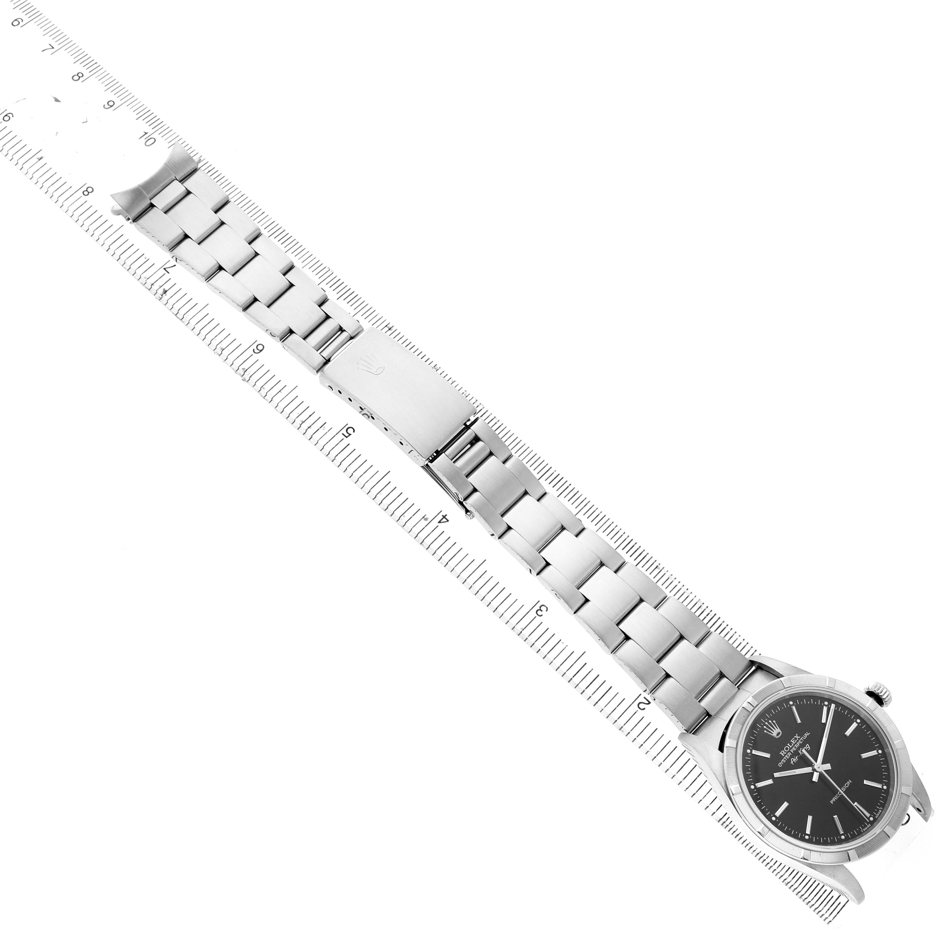 The Rolex Air-King 14010 Men's Stainless Steel Black Dial watch is displayed from an overhead angle, showing its full bracelet and face, aligned with a ruler.