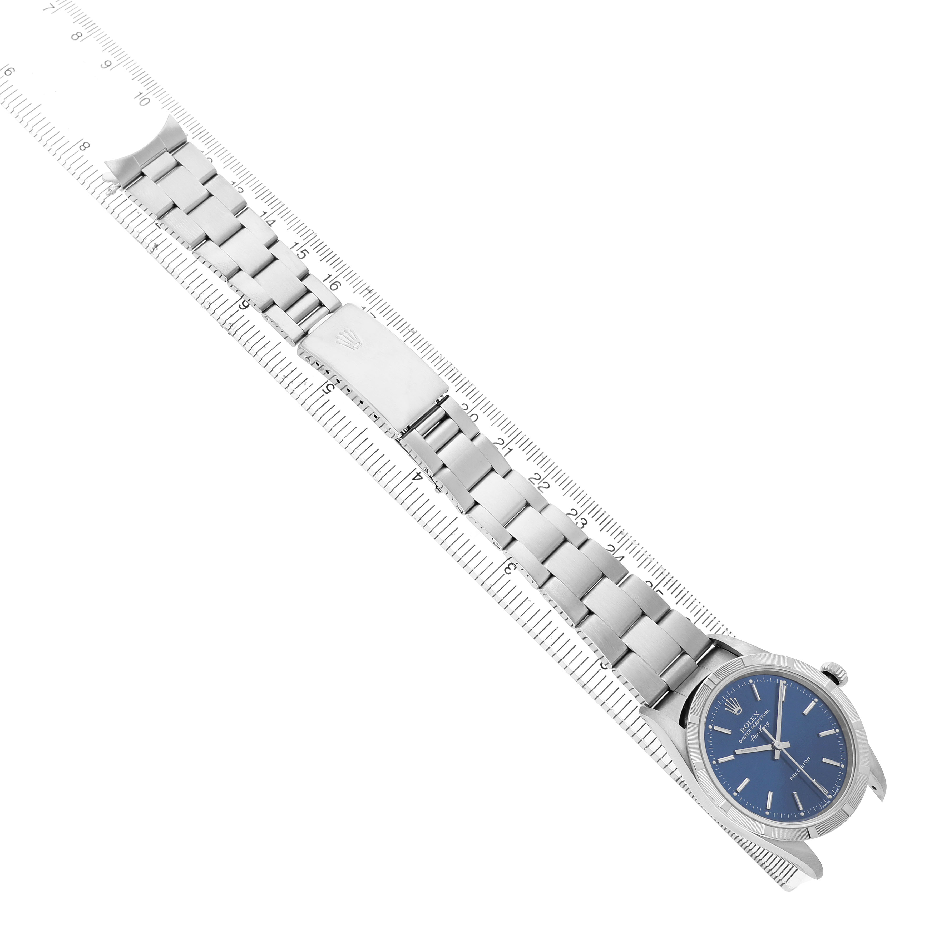 The Rolex Air-King 14010 Men's Stainless Steel Blue Dial watch is shown from a top-down angle, displaying the bracelet, clasp, and blue dial alongside a ruler.