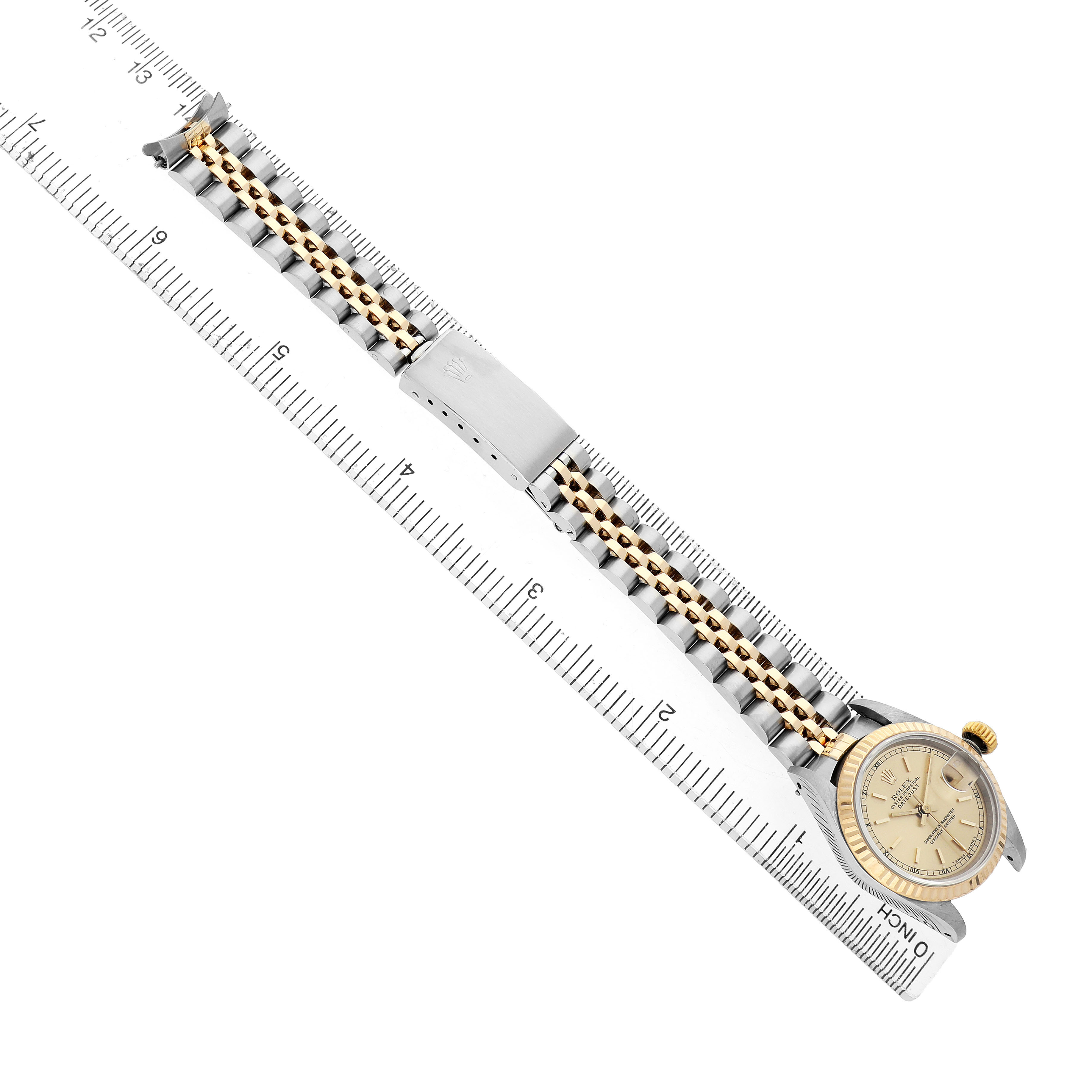 The Rolex Datejust 69173 Women's Steel and Gold (two tone) Champagne Dial watch is shown from a top view, highlighting the full bracelet and dial next to a ruler for scale.