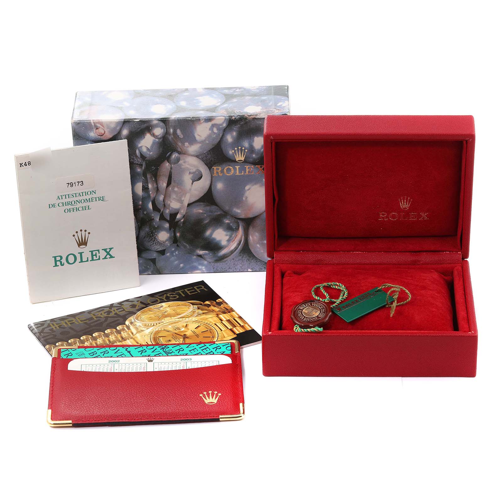 The image shows packaging and accessories for a Rolex Datejust 79173 Women's Steel and Gold (two tone) White Dial 79173 Women's Steel and Gold (two tone) White Dial watch, including a box, manual, tags, and a red pouch with a booklet.