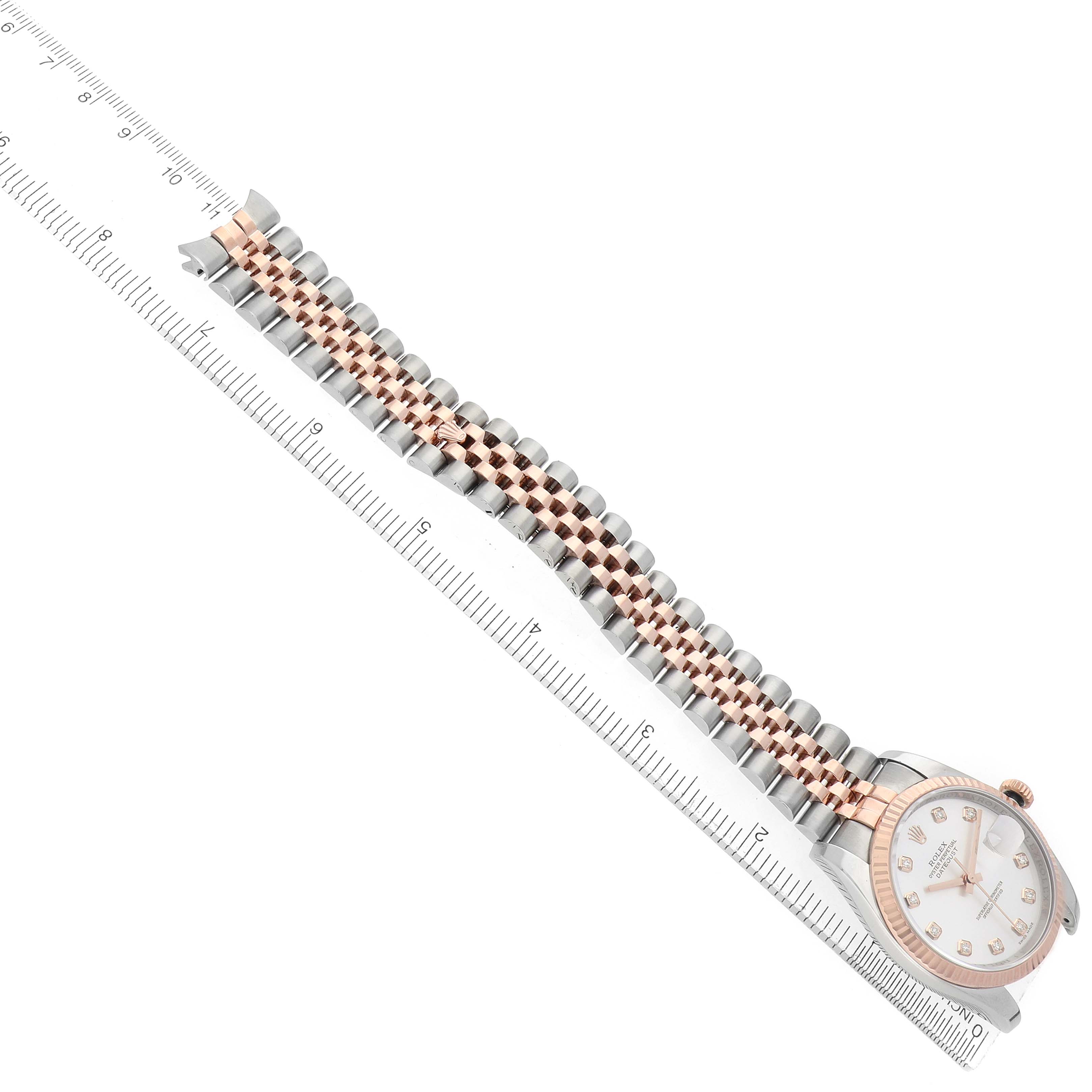 The Rolex Datejust 116231 Men's Steel and Gold (two tone) Silver Dial watch is shown at an angle with its two-tone bracelet and part of the dial, alongside a ruler for scale.