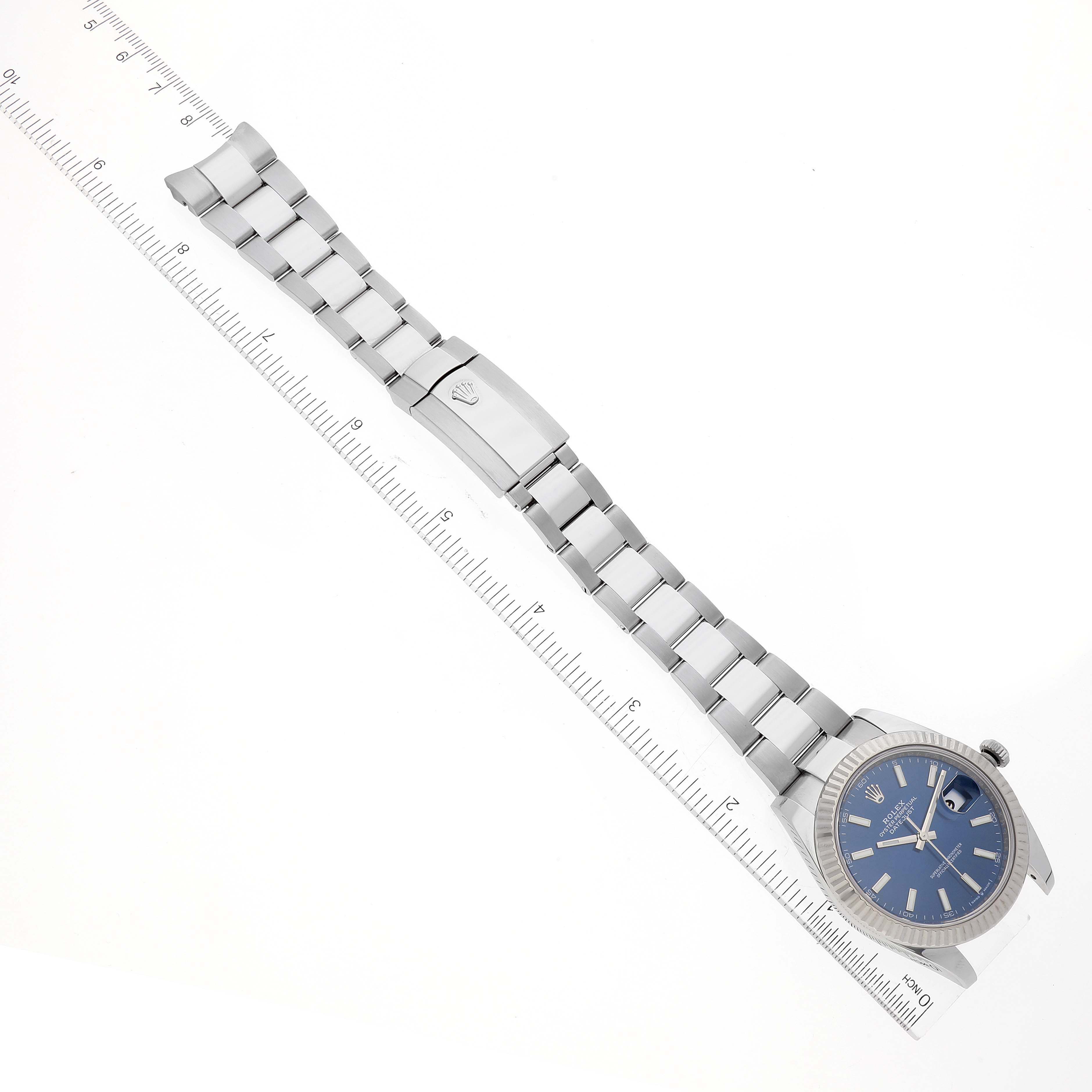 The image shows the side angle of a Rolex Datejust 41 126334 Men's Stainless Steel Blue Dial 126334 Men's Stainless Steel Blue Dial watch, highlighting its bracelet and blue dial, with a ruler for scale.