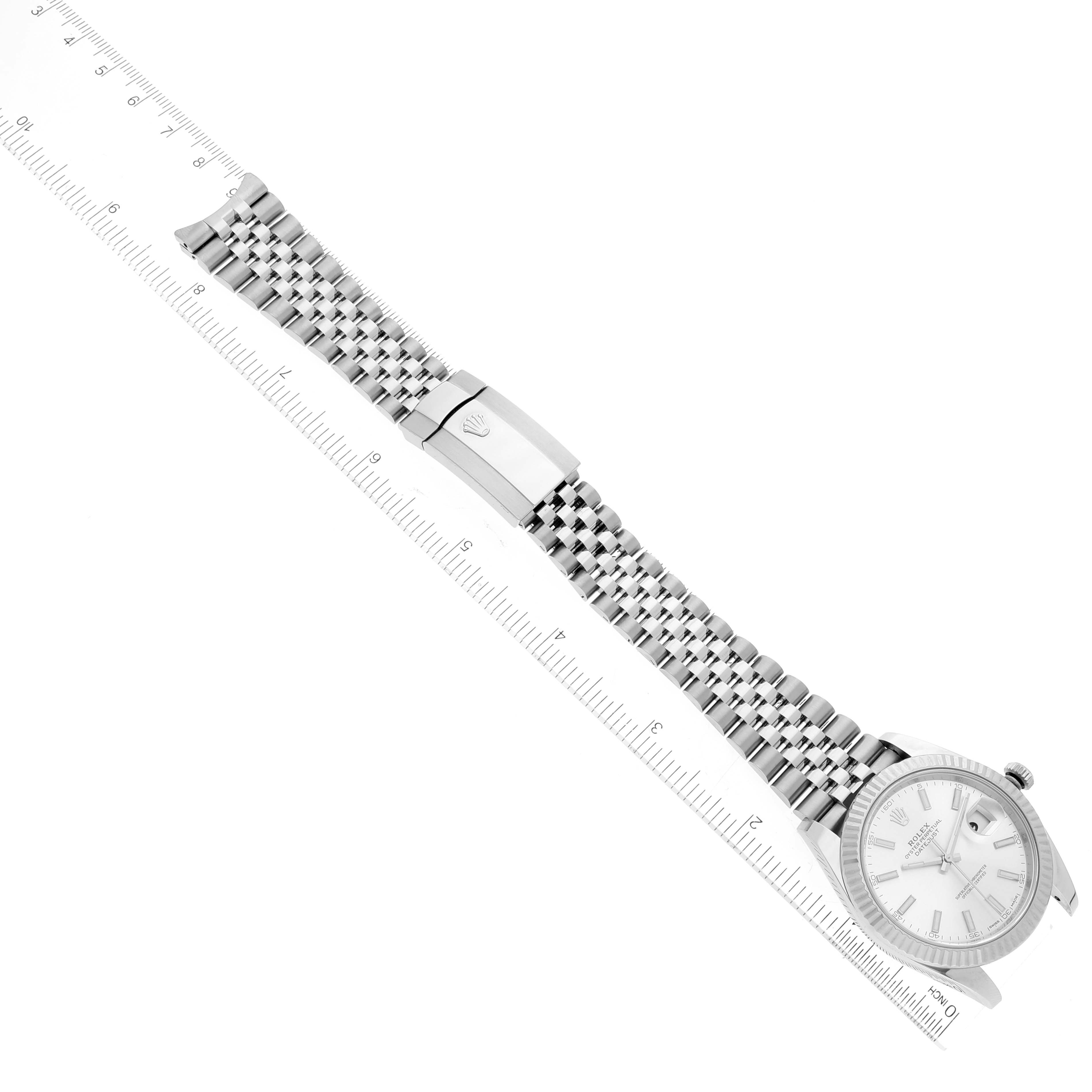 The image shows an overhead view of a Rolex Datejust 41 126334 Men's Stainless Steel Silver Dial 126334 Men's Stainless Steel Silver Dial watch, highlighting the face, bezel, bracelet, and clasp positioned along a ruler.