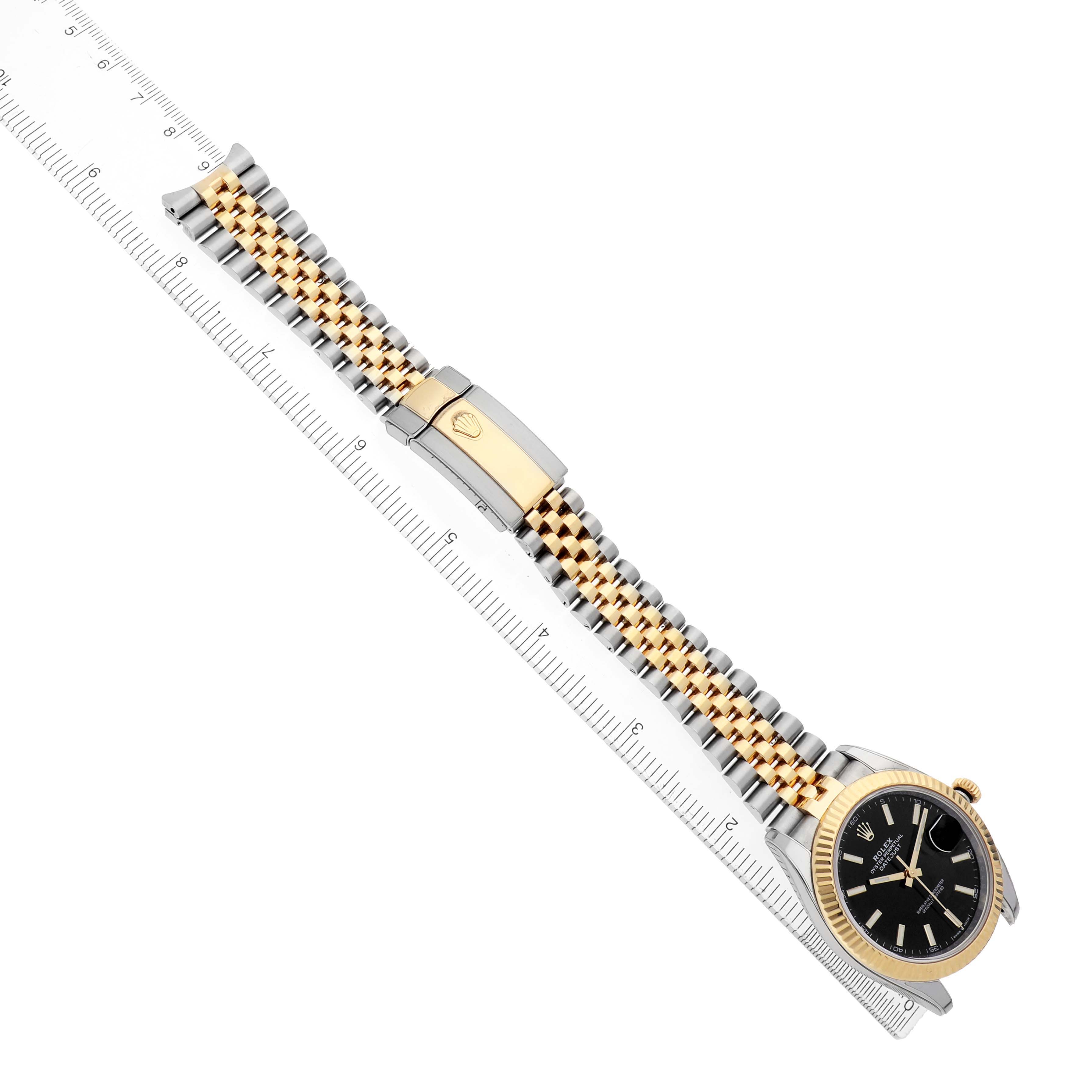 The Rolex Datejust 41 126333 Men's Steel and Gold (two tone) Black Dial is shown at an angle displaying its full bracelet, clasp, and face next to a ruler for scale.
