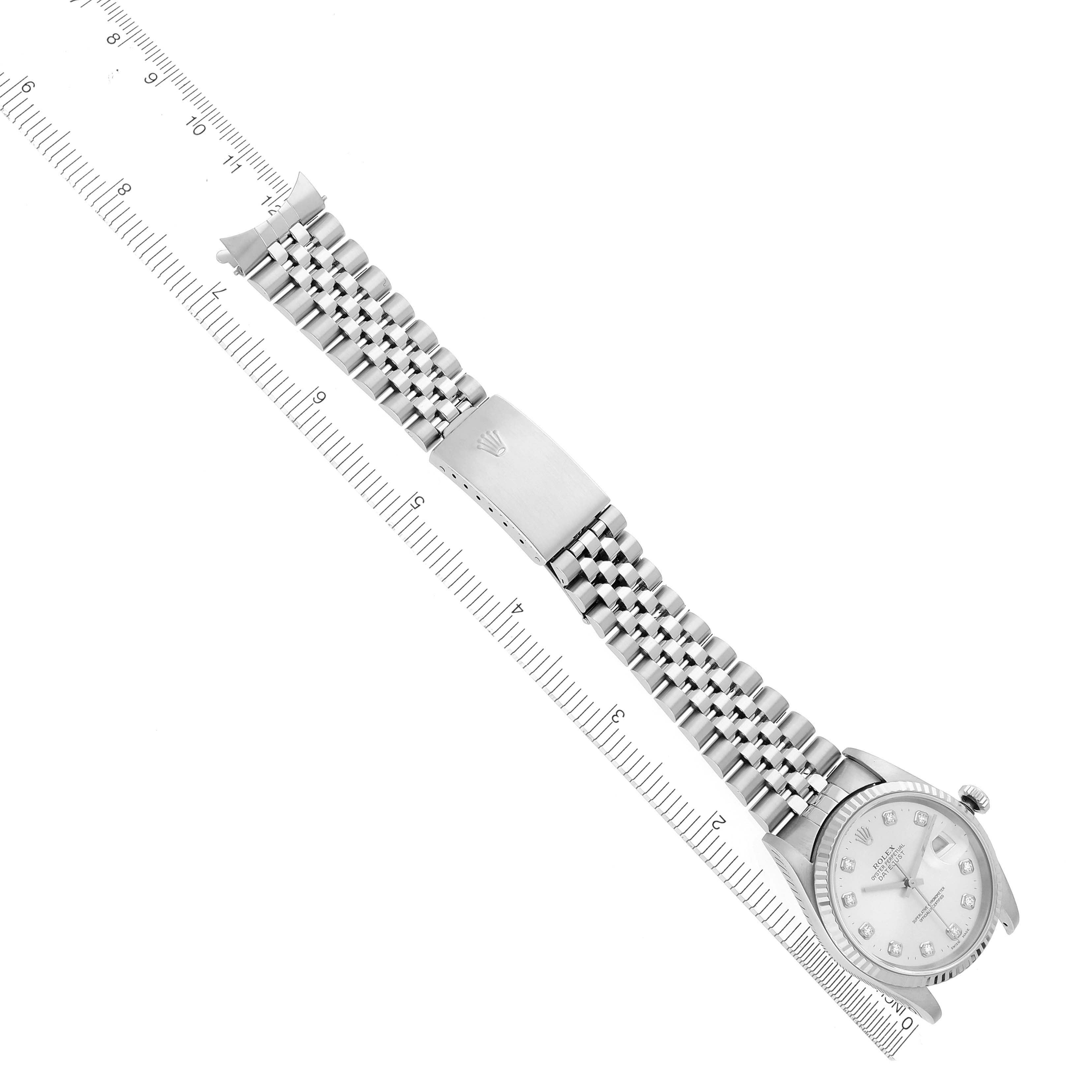 The image shows a Rolex Datejust 16234 Men
s Stainless Steel Silver Dial 16234 Men
s Stainless Steel Silver Dial watch from a top-down angle, highlighting the face, bezel, and bracelet alongside a ruler.