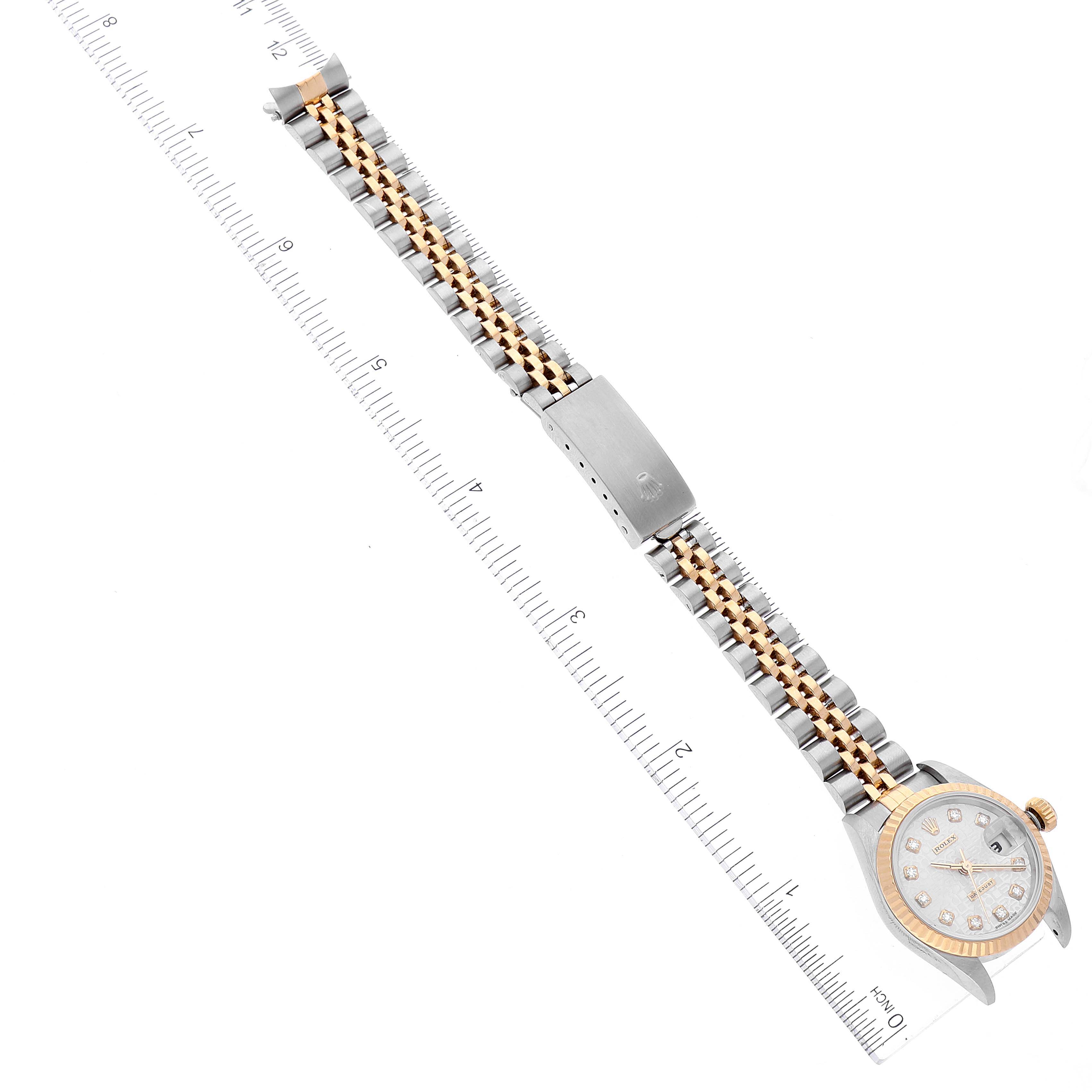 This Rolex Datejust 69173 Women's Steel and Gold (two tone) Silver Dial 69173 Women's Steel and Gold (two tone) Silver Dial watch is shown from a top-down view, with its full band stretched alongside a ruler for measurement.