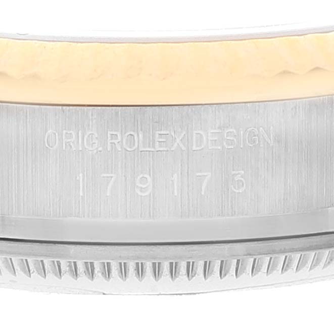 This close-up image shows the etched serial number and part of the bezel of a Rolex Datejust 179173 Women's Steel and Gold (two tone) Black Dial 179173 Women's Steel and Gold (two tone) Black Dial watch.