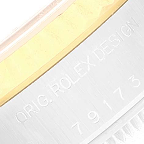 This close-up image of the Rolex Datejust 79173 Women's Steel and Gold (two tone) Champagne Dial 79173 Women's Steel and Gold (two tone) Champagne Dial watch shows the engraved writing on the inner bezel or case back.