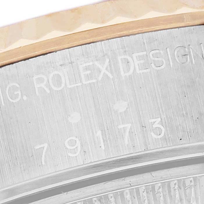 The image shows a close-up of the Rolex Datejust 79173 Women's Steel and Gold (two tone) White Dial 79173 Women's Steel and Gold (two tone) White Dial watch case, highlighting the serial number and design text.