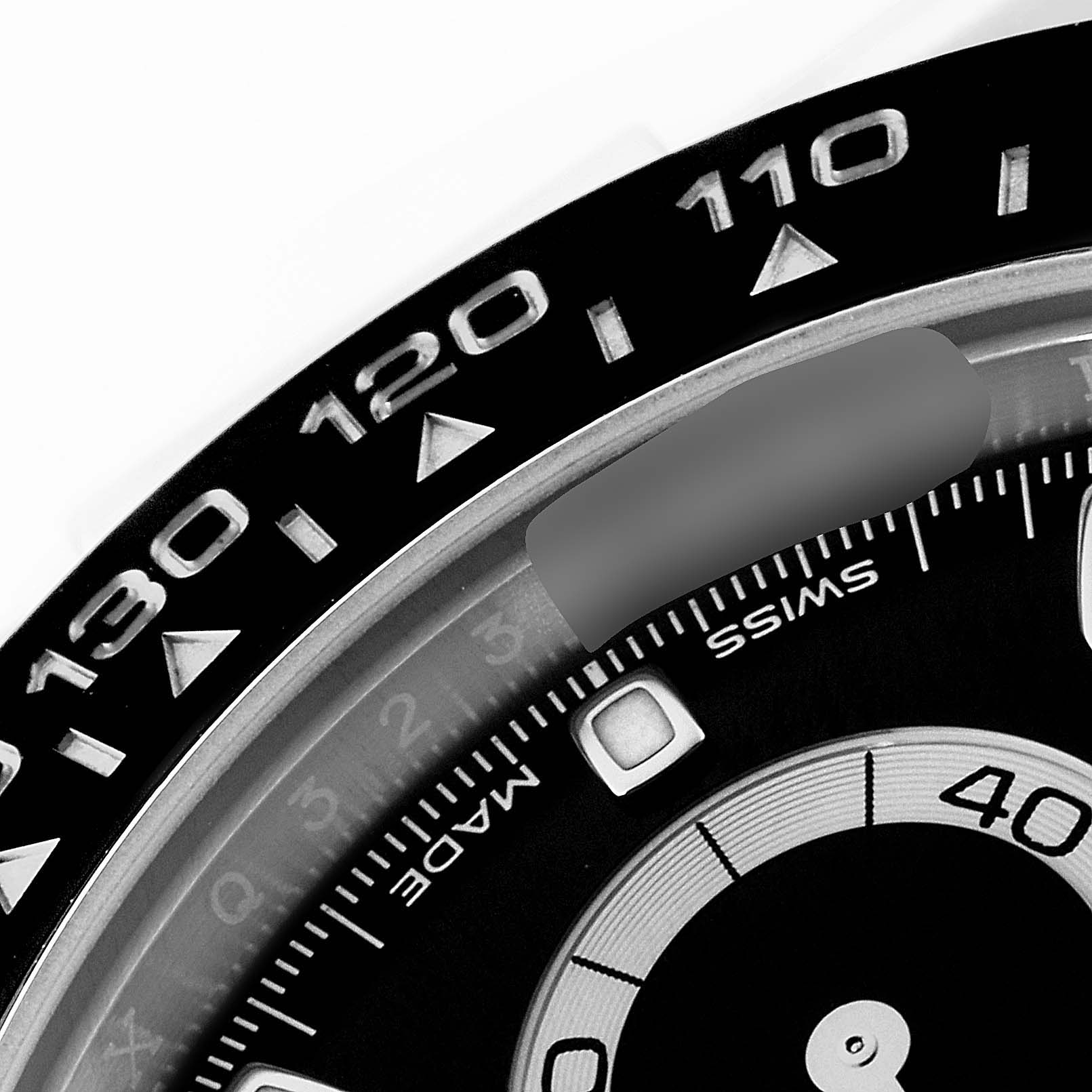 The image shows a close-up of the bezel and part of the dial of a Rolex Daytona 116500 Men's Stainless Steel Black Dial 116500 Men's Stainless Steel Black Dial watch.