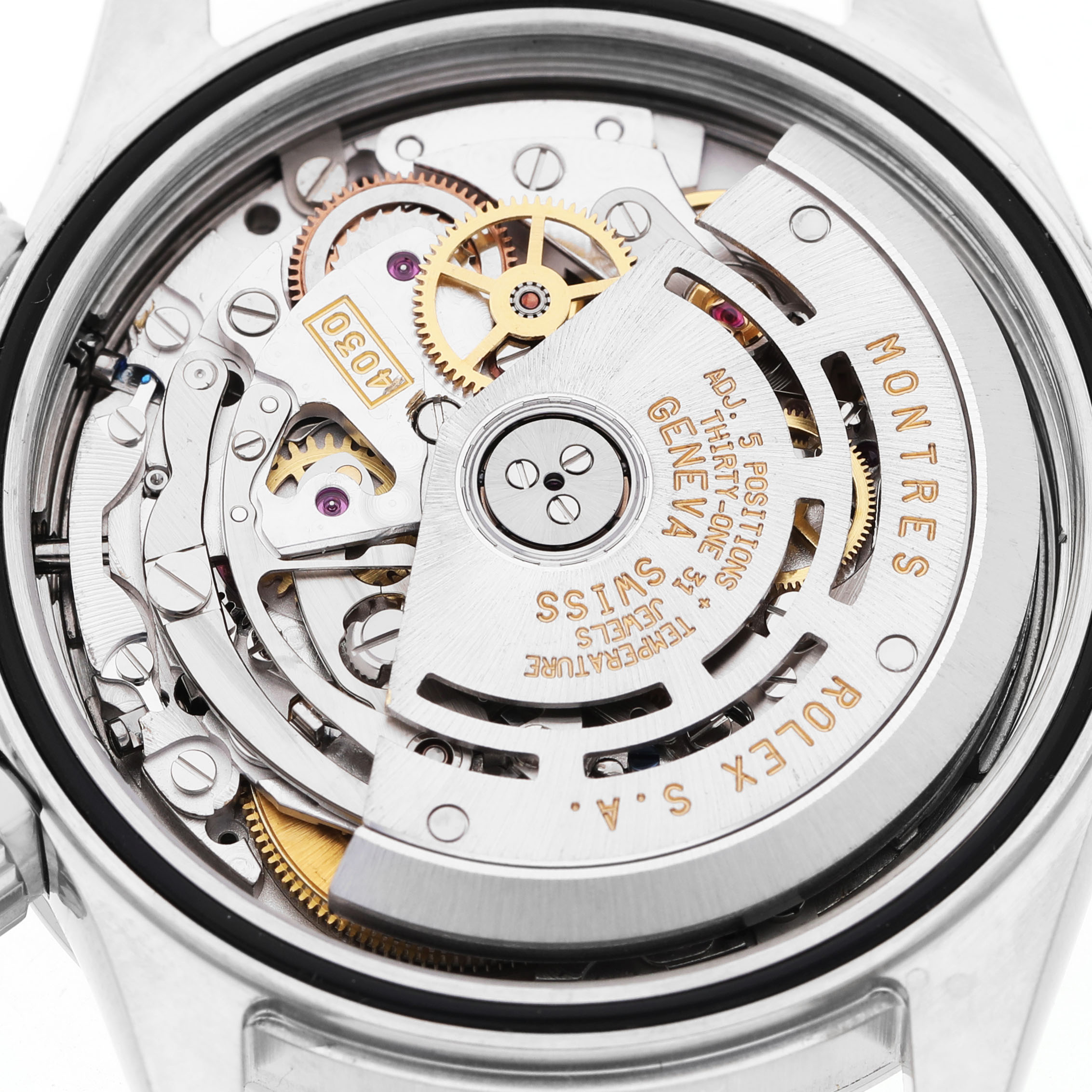 The image shows a detailed view of the movement mechanism of a Rolex Daytona 16520 Men's Stainless Steel White Dial watch, highlighting gears and the rotor.