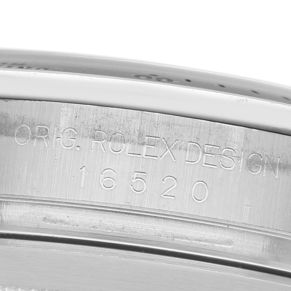 The image shows the side of a Rolex Daytona 16520 Men's Stainless Steel White Dial, highlighting the engraved model number 16520 and the "Orig. Rolex Design" text.