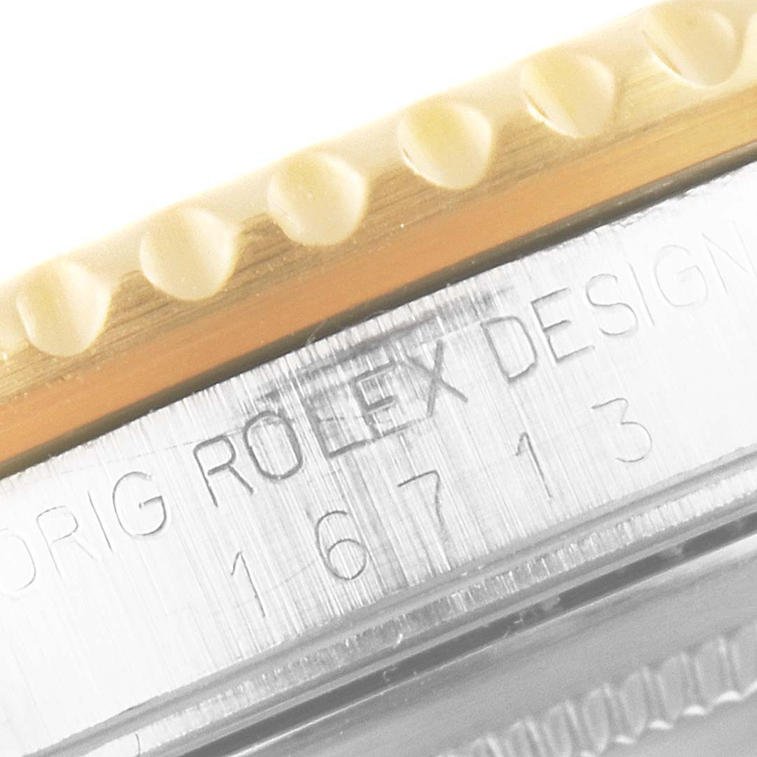 This close-up angle of the Rolex GMT-Master 16713 Men's Steel and Gold (two tone) Champagne Dial 16713 Men's Steel and Gold (two tone) Champagne Dial watch shows part of the bezel and engraved case detailing the design and model number.