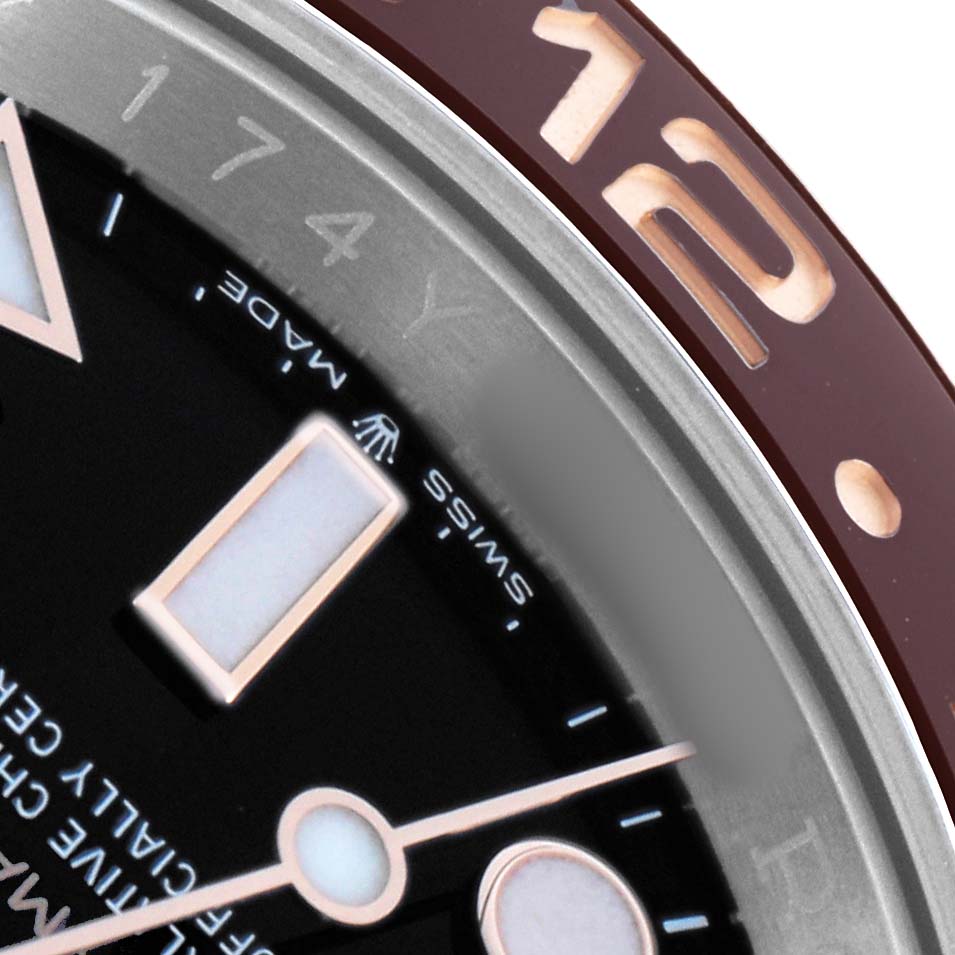 The image shows a close-up of the Rolex GMT-Master 126711 Men
s Steel and Gold (two tone) Black Dial
s dial and bezel, highlighting the hour markers and "12" on the bezel.