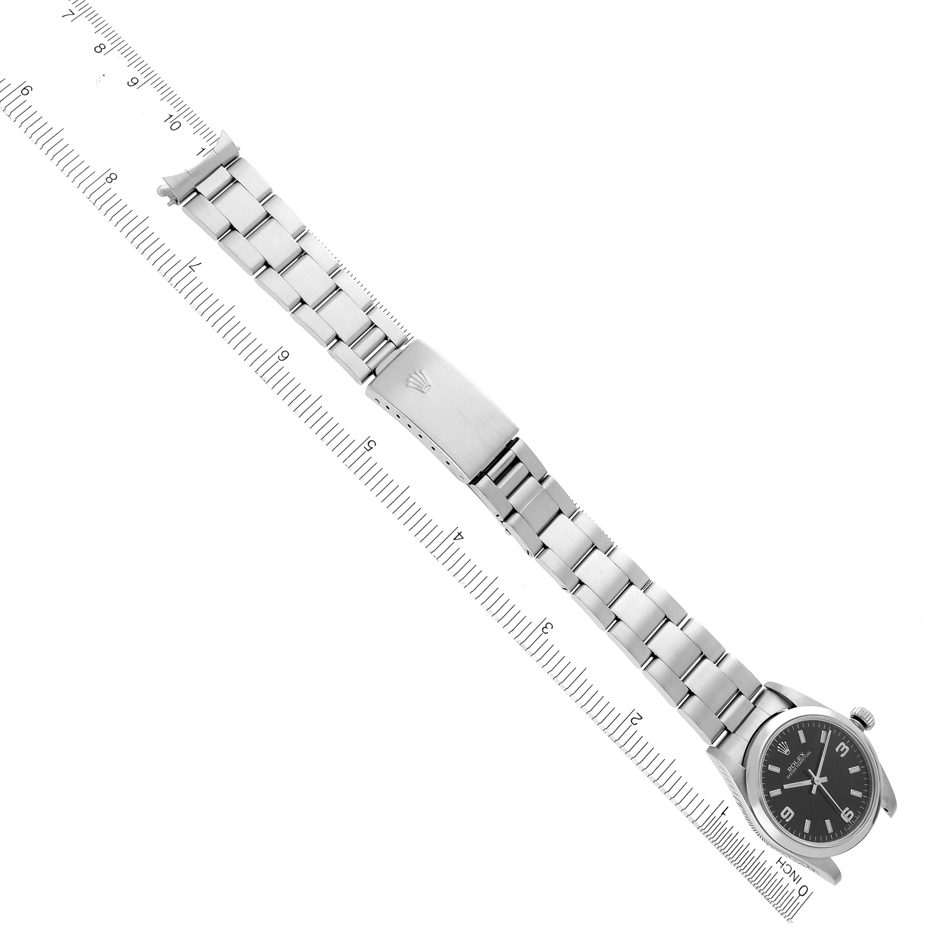 The image shows a Rolex Mid-Size 77080 Women's Stainless Steel Black Dial 77080 Women's Stainless Steel Black Dial watch at an angled view, displaying its full bracelet and clasp against a ruler for size reference.