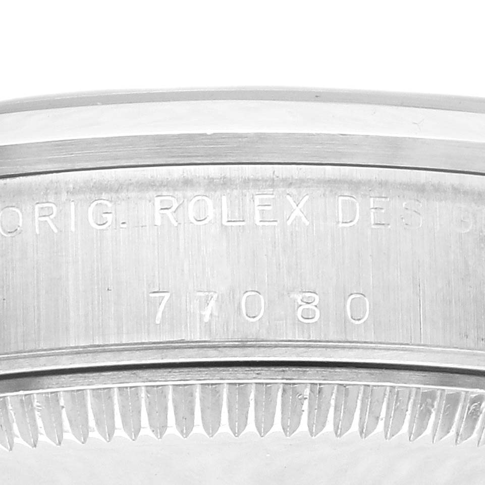 The image shows a close-up of the casing side of a Rolex Mid-Size 77080 Women's Stainless Steel Black Dial 77080 Women's Stainless Steel Black Dial watch, highlighting engraving details.