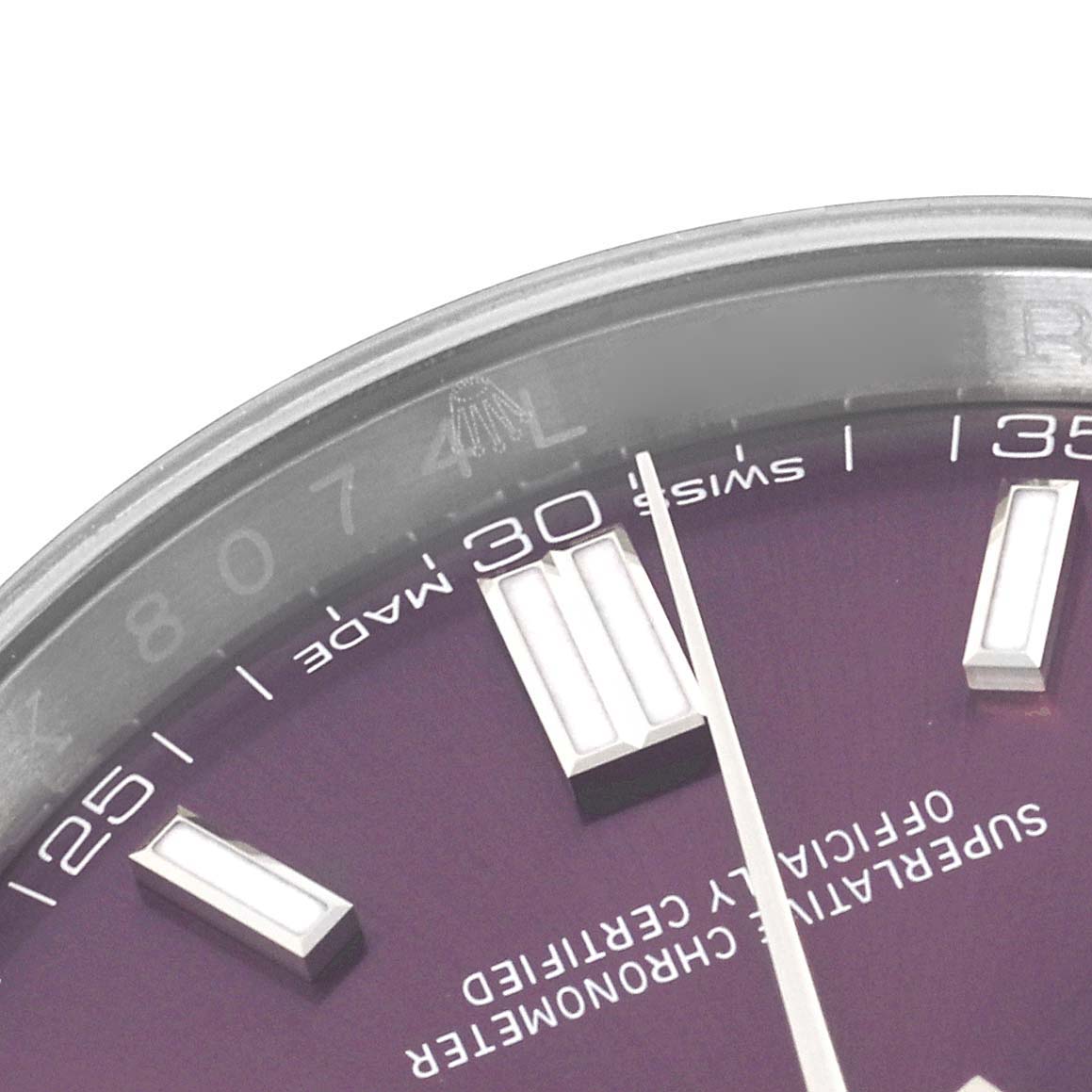 The image shows a close-up of the Rolex Oyster Perpetual 116000 Men's Stainless Steel Purple Dial watch face, focusing on the hour markers and hands at an angle.