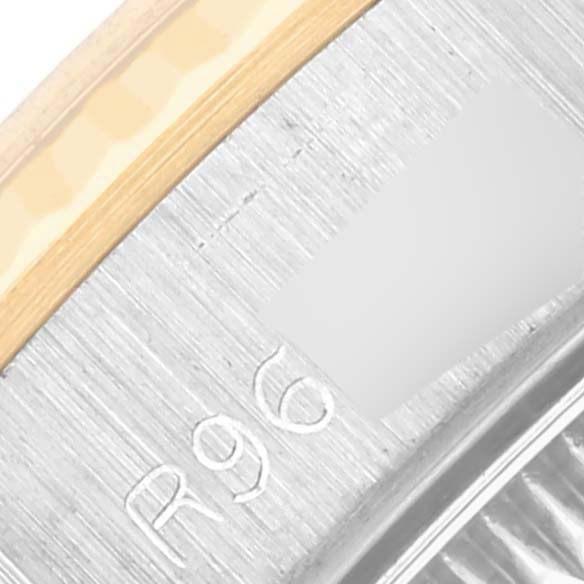 The image shows a close-up of the edge of a Rolex Oyster Perpetual 67193 Women's Steel and Gold (two tone) Champagne Dial 67193 Women's Steel and Gold (two tone) Champagne Dial watch, focusing on engravings and the metal texture.