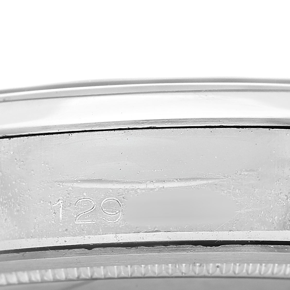 The image shows a close-up of the case side of the Vintage Collection Rolex watch, featuring part of the serial number engraving.