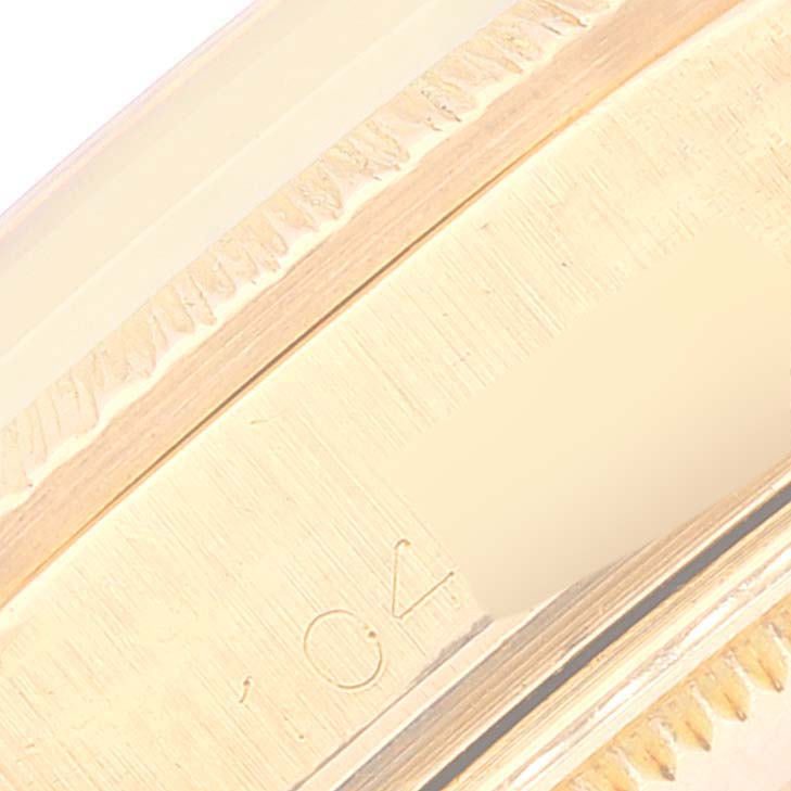 This close-up image shows the engraved bezel and part of the case of a Vintage Collection model by Rolex.