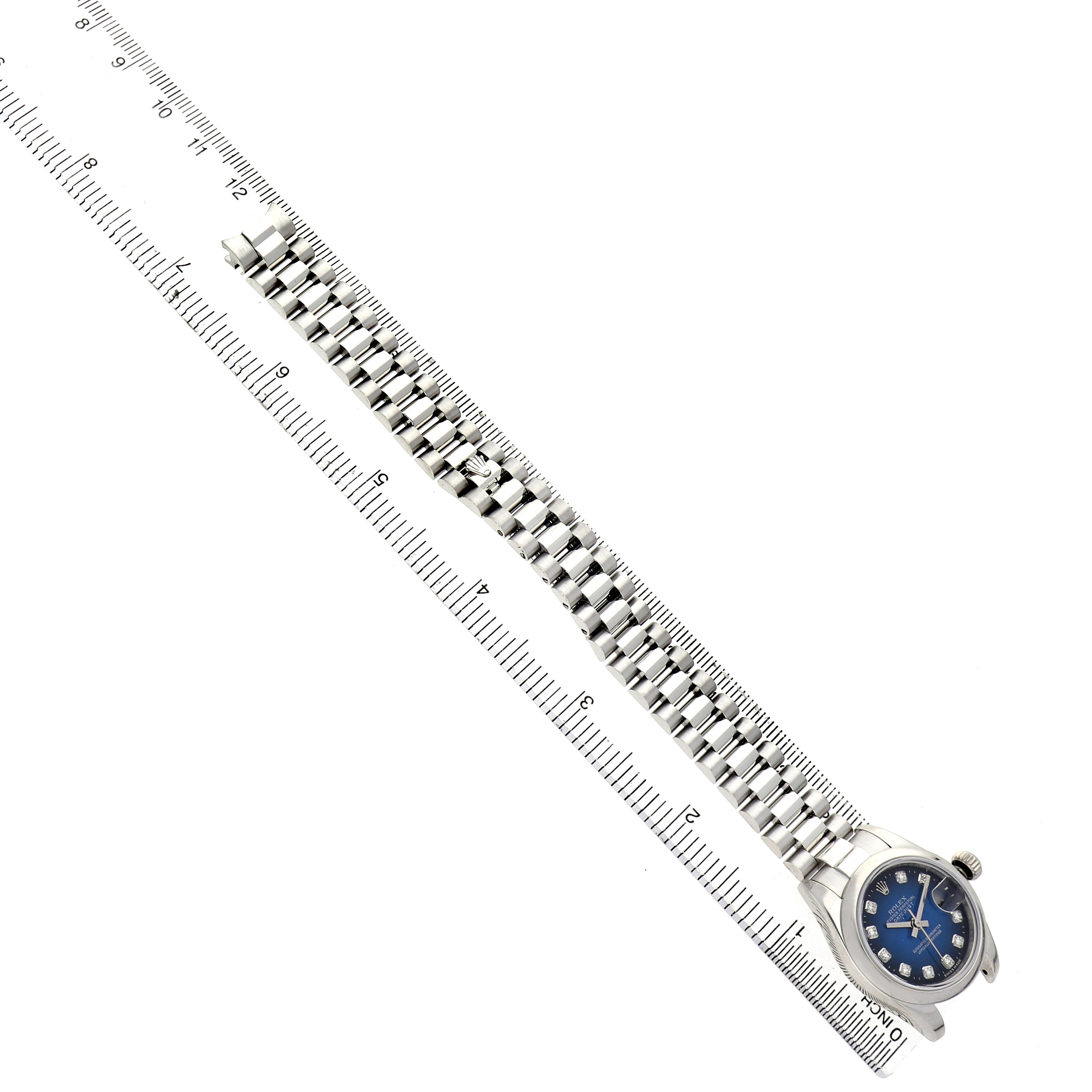 The image shows the Rolex President 179166 Women's Platinum Blue Dial model watch laid flat with its strap extended alongside a ruler for scale.