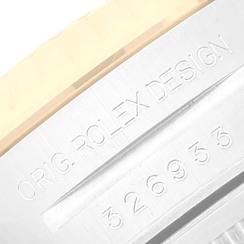 The image shows a close-up of the Sky-Dweller model by Rolex, focusing on part of the bezel and engraved design details.