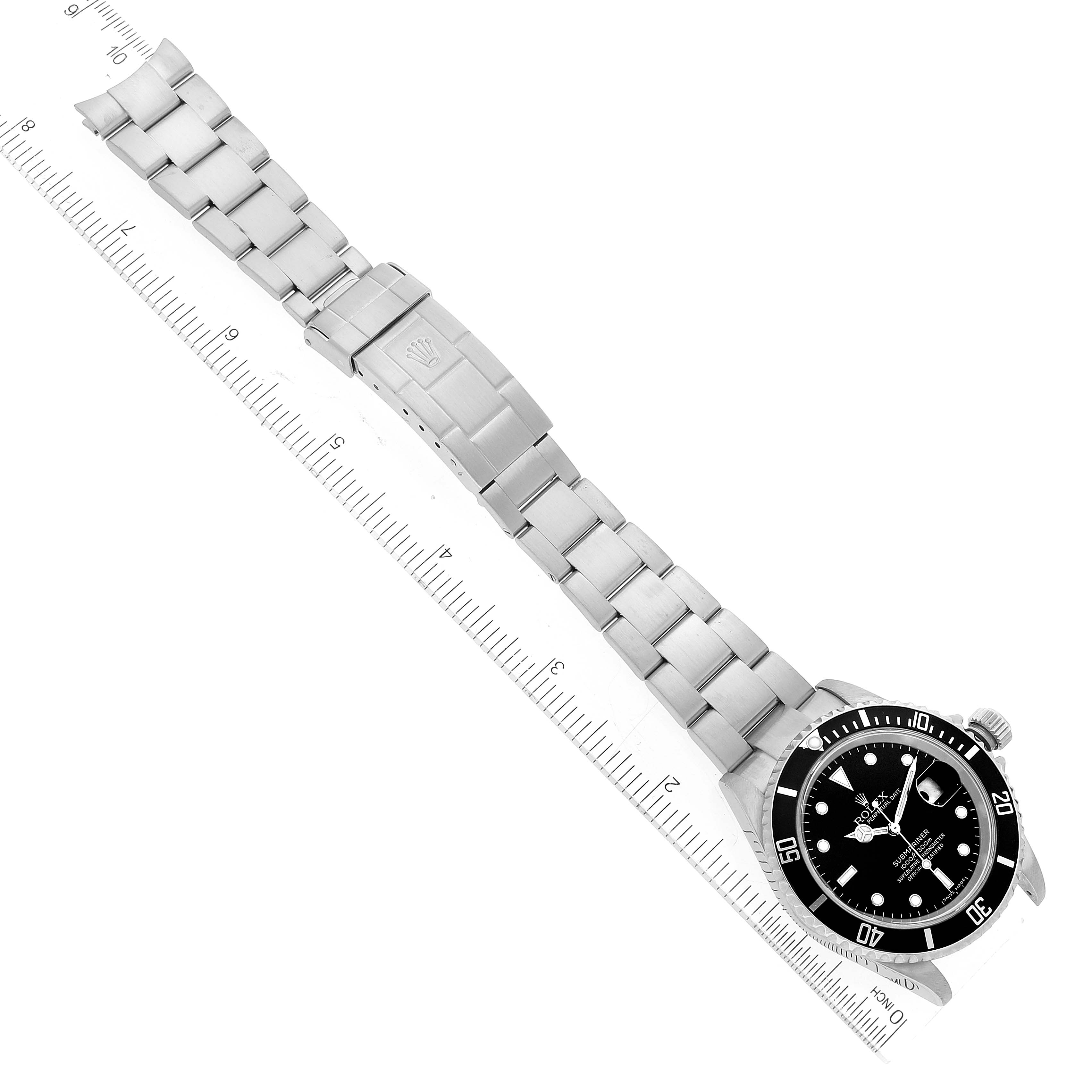 The image shows a top view of a Rolex Submariner 16610 Men's Stainless Steel Black Dial 16610 Men's Stainless Steel Black Dial watch, including the bracelet, clasp, and dial, aligned with a ruler.