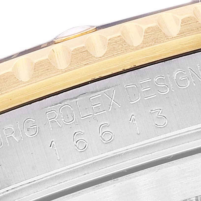 The image shows a close-up of the bezel and engraved case side of a Rolex Submariner 16613 Men's Steel and Gold (two tone) Blue Dial watch.