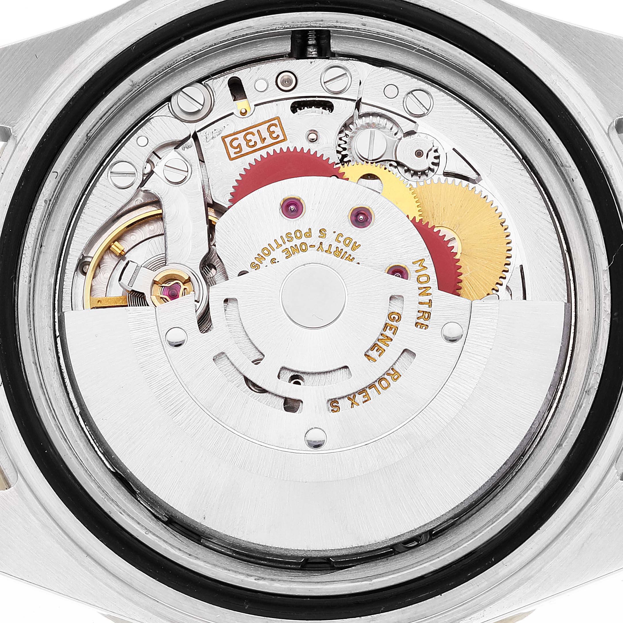 The image shows the movement of a Rolex Submariner 16613 Men's Steel and Gold (two tone) Blue Dial, viewed from the back with gears and mechanical parts visible.