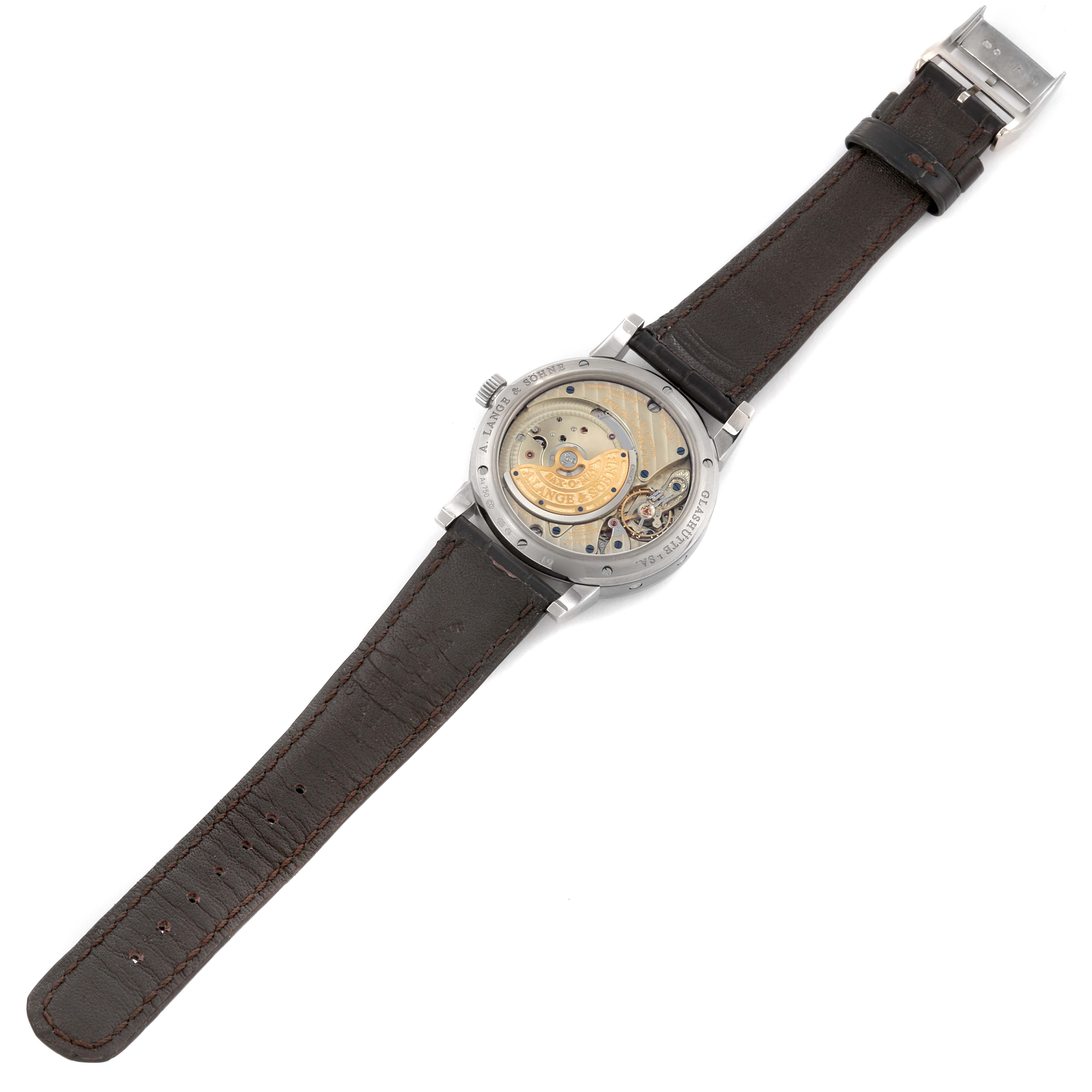 The A. Lange & Sohne Saxonia 330.026 Men's White Gold Silver Dial watch is shown from the back, displaying its mechanical movement and leather strap.