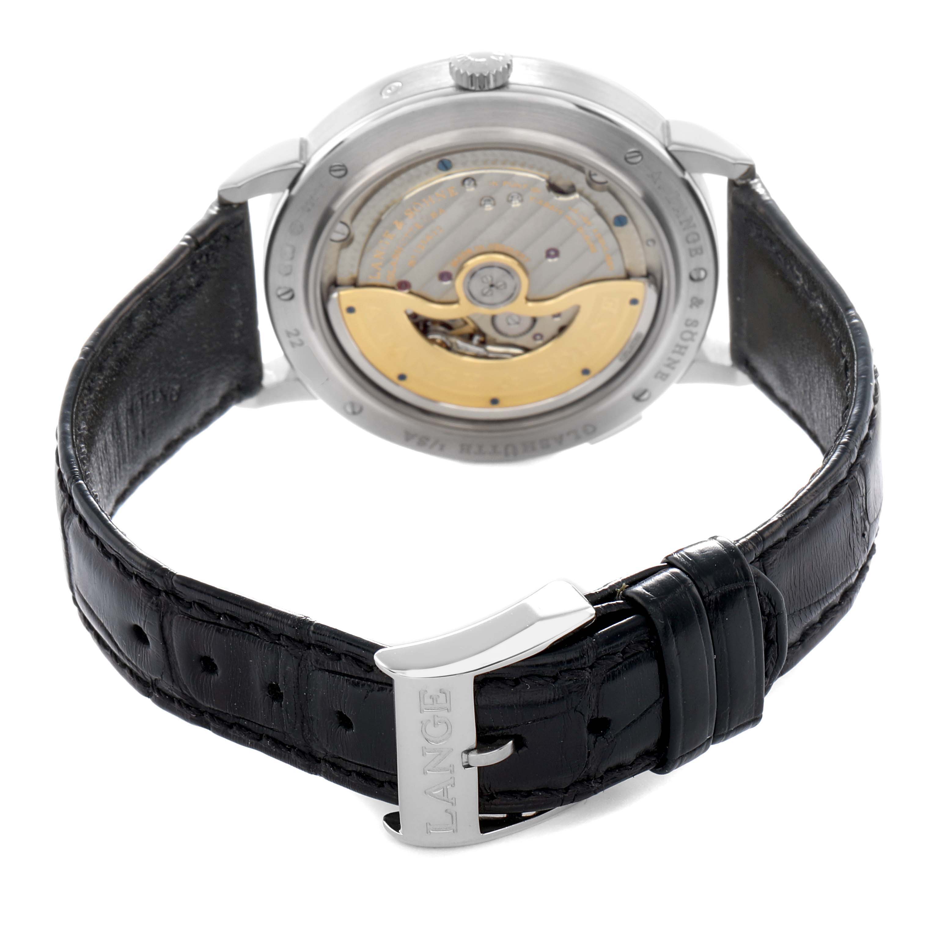 The A. Lange 
Sohne Saxonia 384.026 Men
s White Gold Silver Dial watch is shown from the back, highlighting the movement and black leather strap.