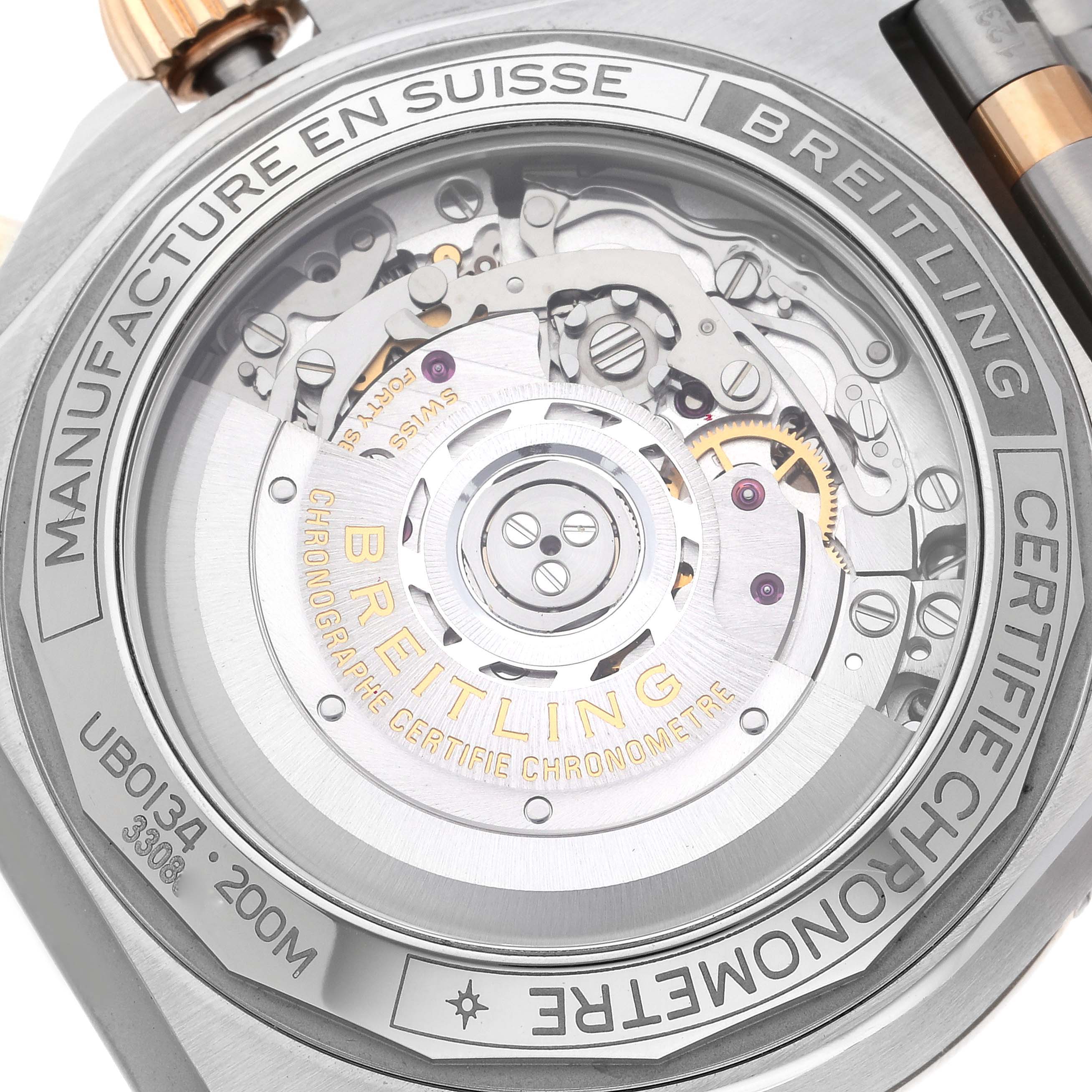 The image shows the back of a Breitling Chronomat UB0134 Men's Steel and Gold (two tone) Grey Dial UB0134 Men's Steel and Gold (two tone) Grey Dial watch, highlighting its intricate mechanical movement and branding.