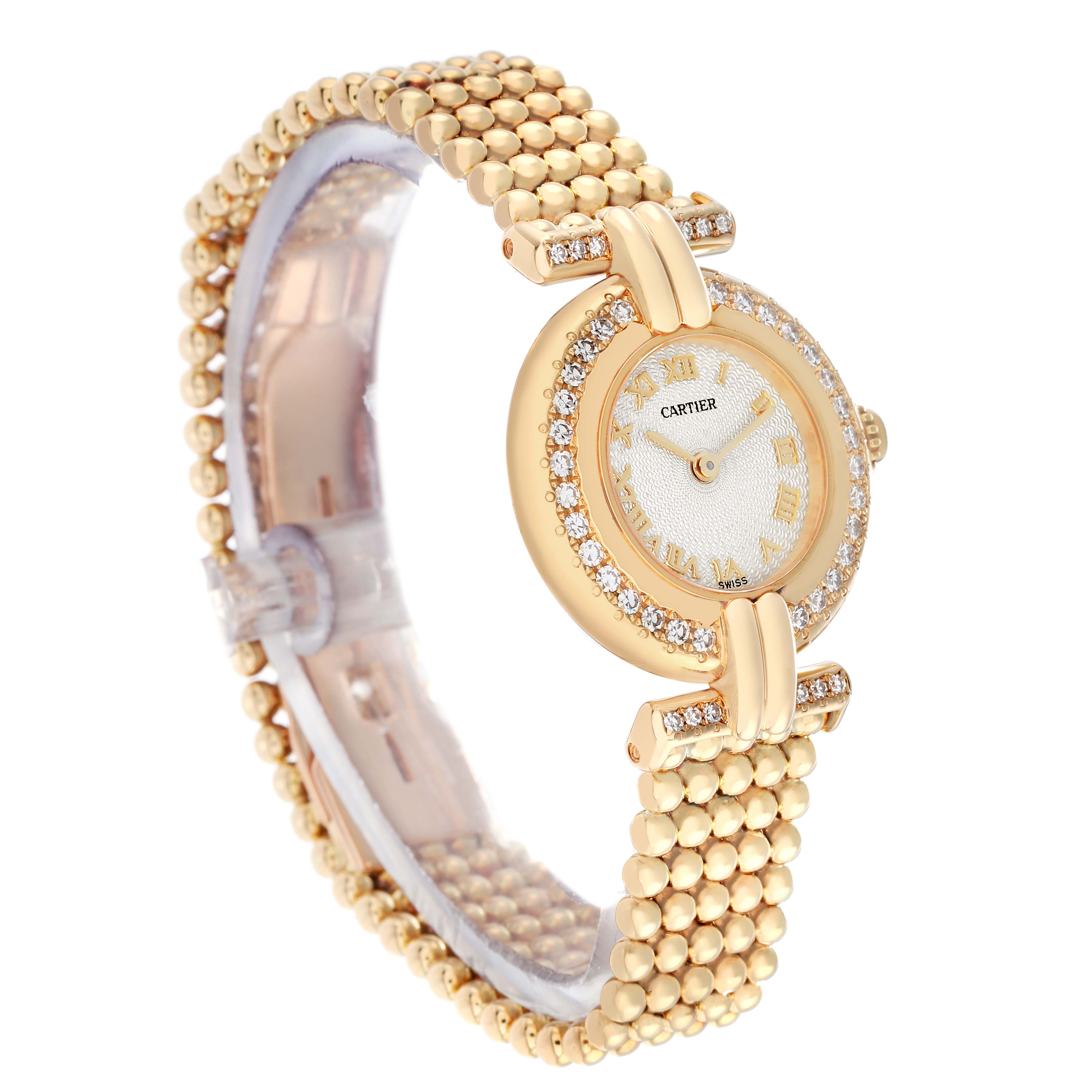 The Cartier Colisee WB1018A8 Women
s Yellow Gold Silver Dial watch is shown from a three-quarter angle, highlighting its gold band, diamond bezel, and Roman numeral dial.