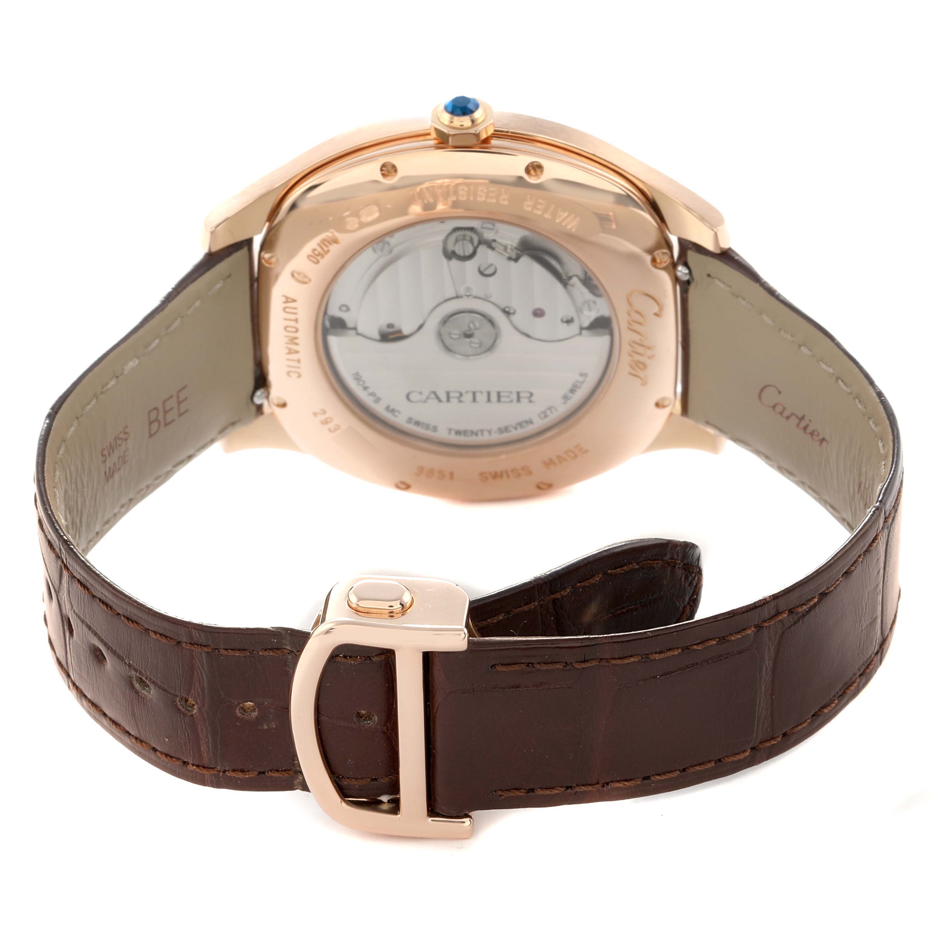 The Calibre de Cartier watch is shown from the back, displaying its transparent case back and automatic movement, with a leather strap.