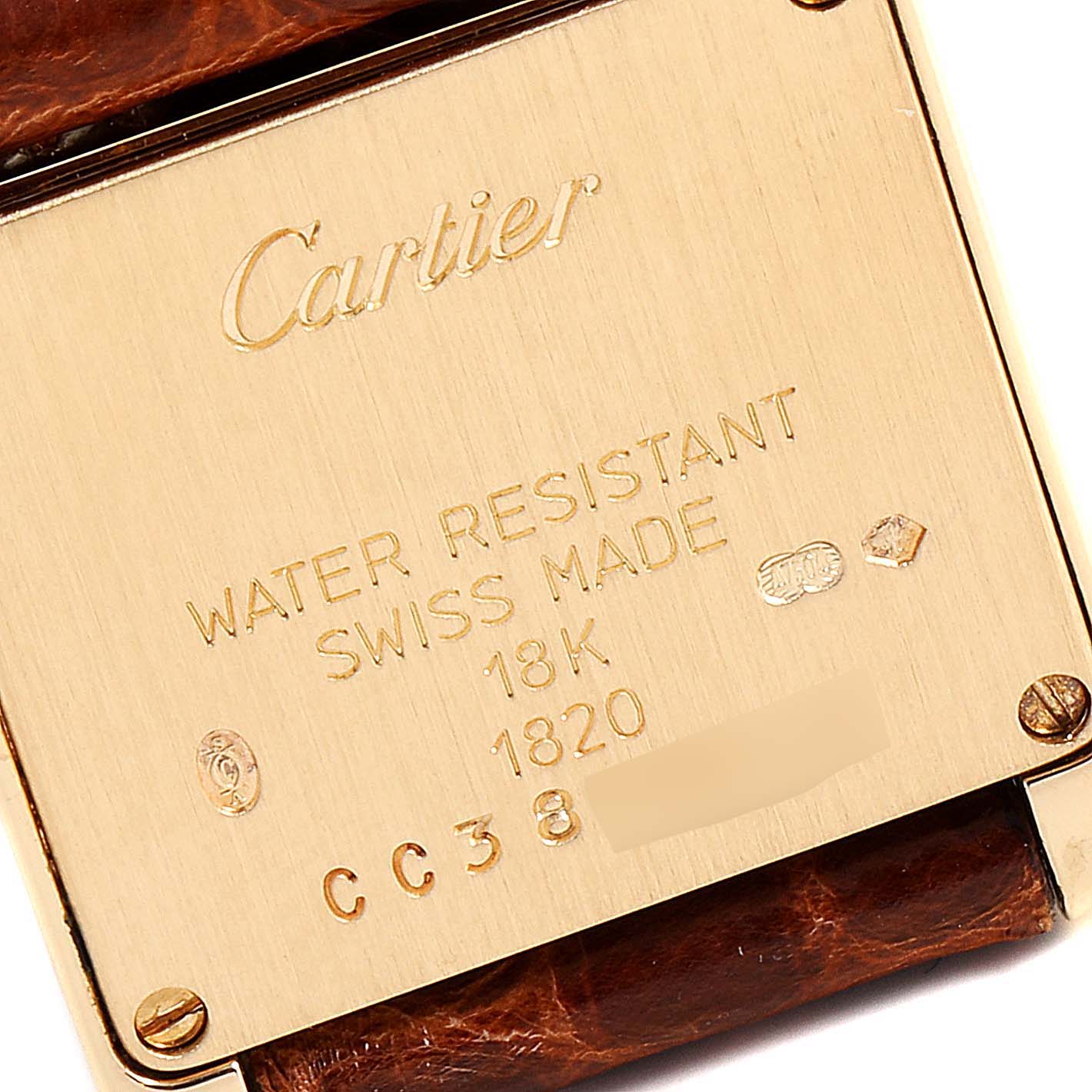 The image shows the back case of a Cartier Tank Francaise W5000256 Women's Yellow Gold Silver Dial W5000256 Women's Yellow Gold Silver Dial watch with engravings indicating water resistance, Swiss-made, 18K, and serial numbers.