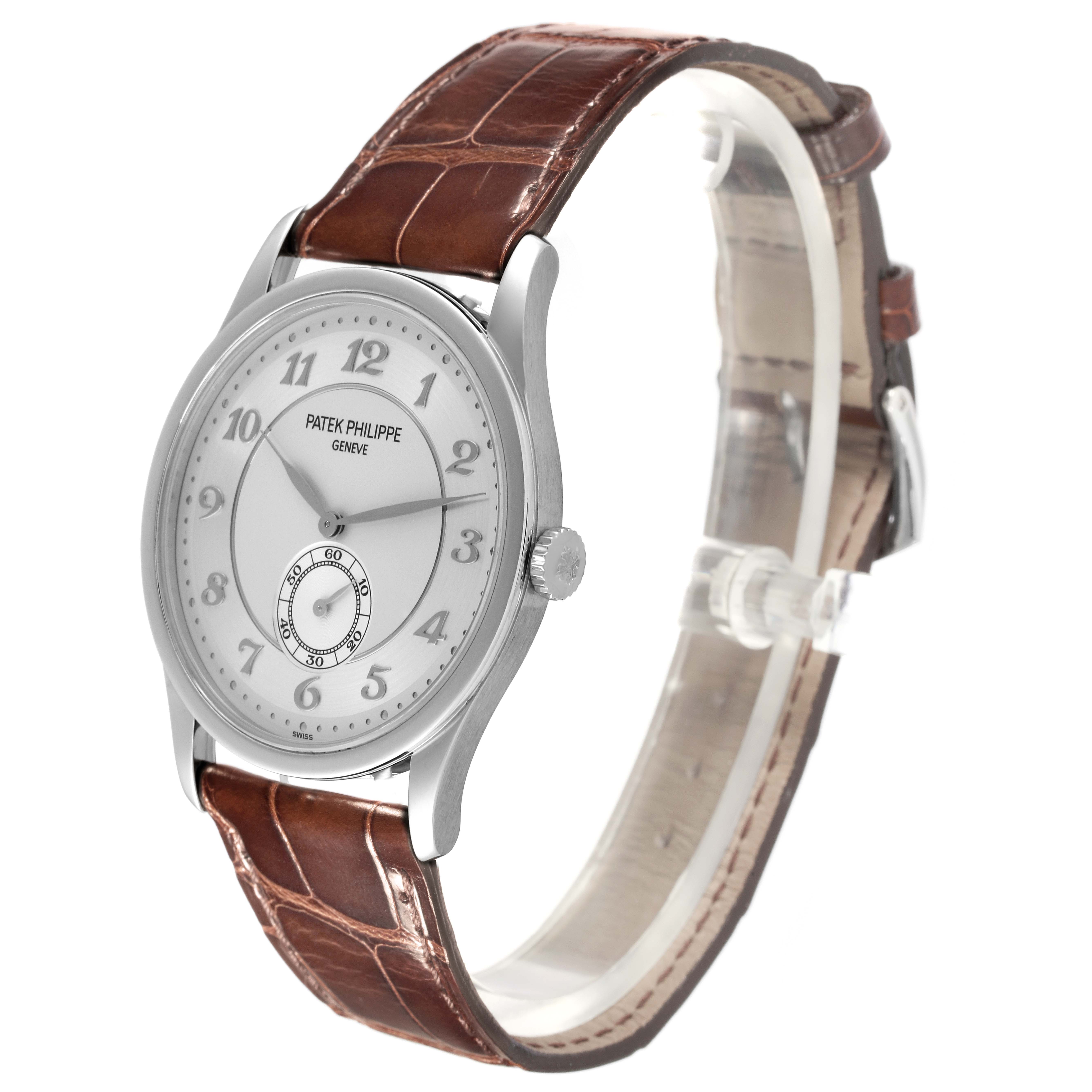 The Patek Philippe Calatrava 5196P-001 Men's Platinum Silver Dial 5196P-001 Men's Platinum Silver Dial watch is shown at a 3/4 angle, highlighting the silver case, dial, and brown leather strap.