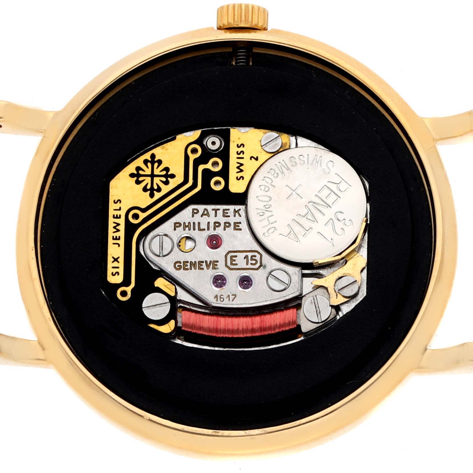 The image shows a close-up of the movement and inner mechanics of the Patek Philippe Calatrava 4819J Women
s Yellow Gold White Dial watch.