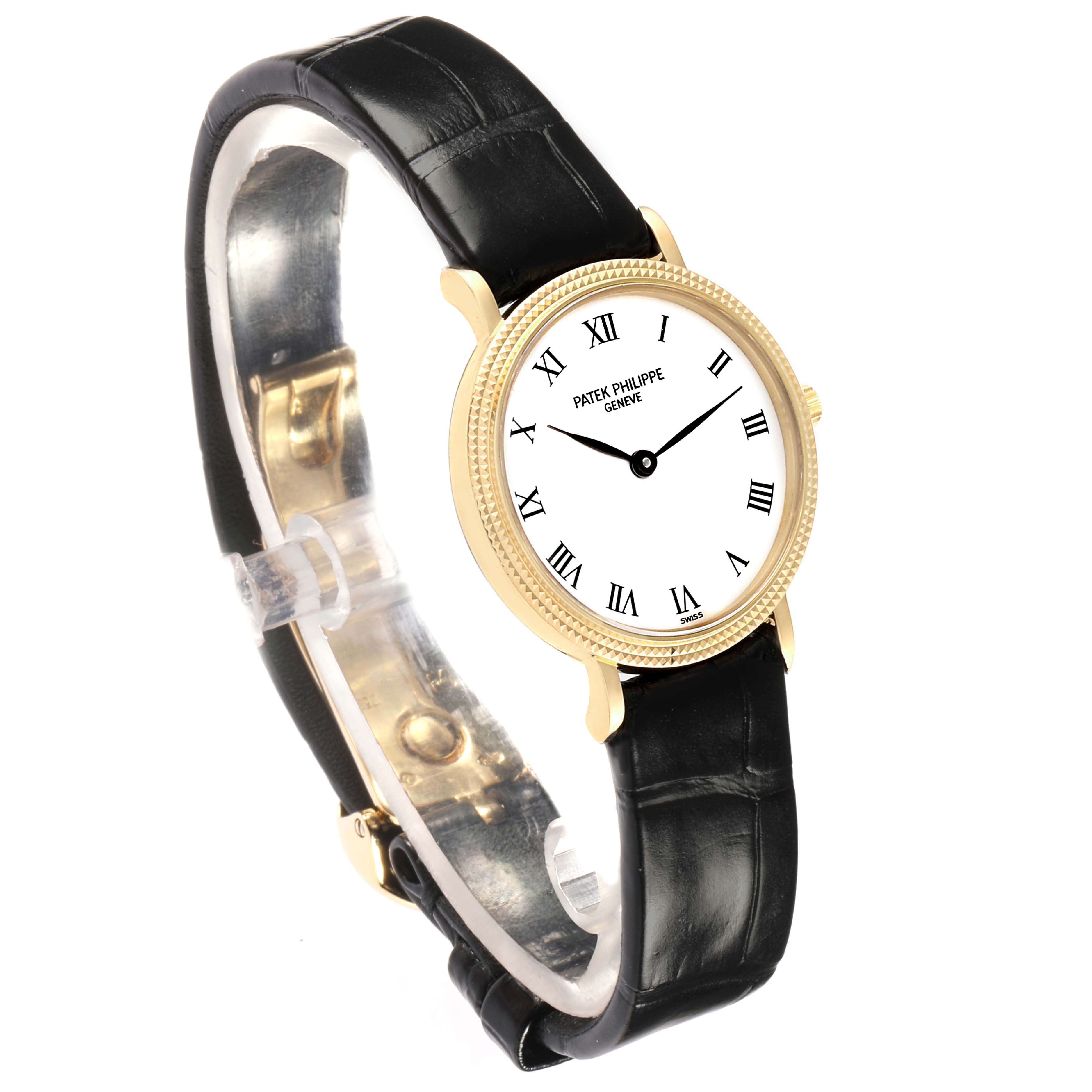 The Patek Philippe Calatrava 4819J Women
s Yellow Gold White Dial watch is shown at a slight angle, highlighting the dial, bezel, and black leather strap.