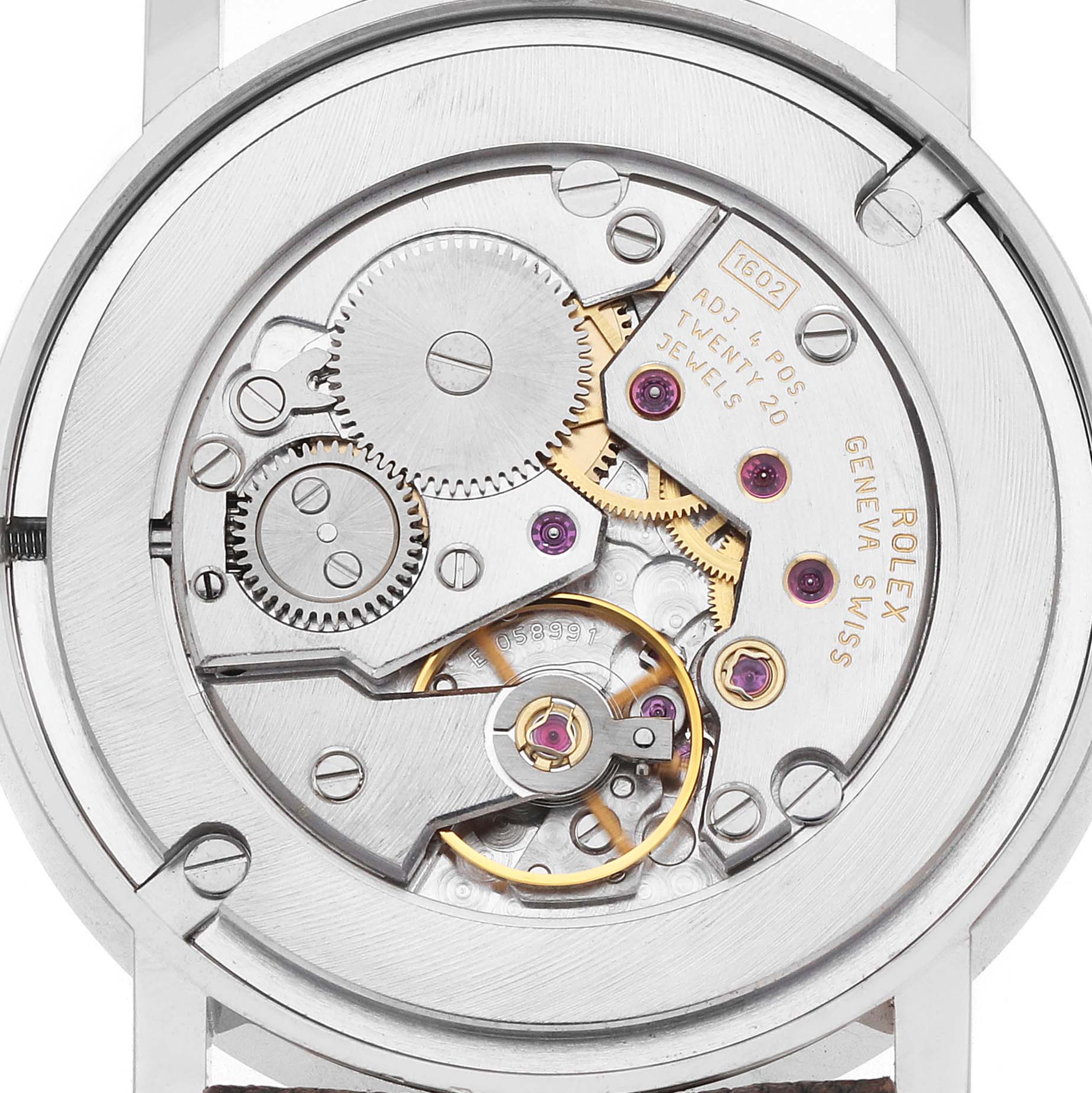 The image shows the movement of a Rolex Cellini 5115 Men
s White Gold Silver Dial watch from a top-down angle, highlighting gears and jewels in the mechanism.